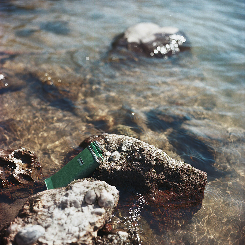 Portland Film Photographer - Flask of Cascade Mountain Gin sitting on the shore of Sandy River - Rolleiflex