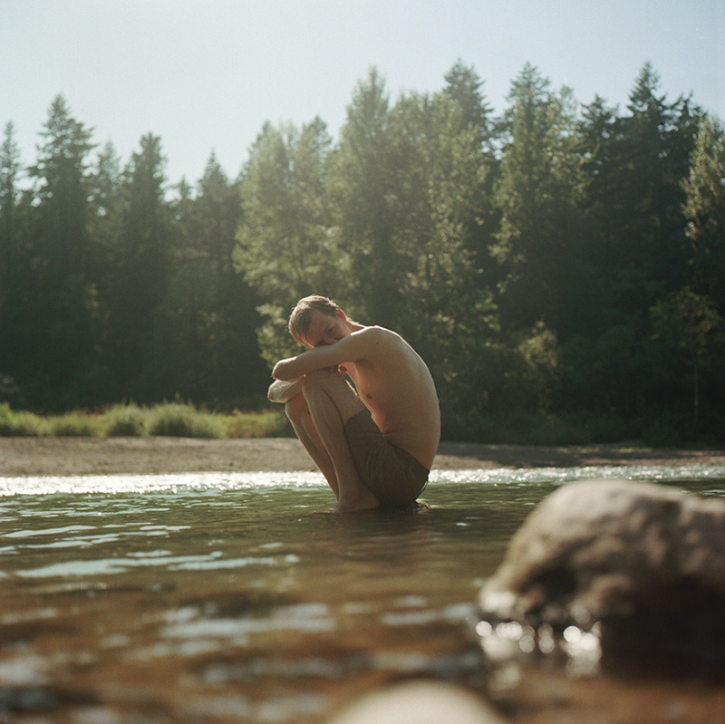 Portland Film Photographer - Rolleiflex portrait of Chris sitting on the rocks of Sandy River