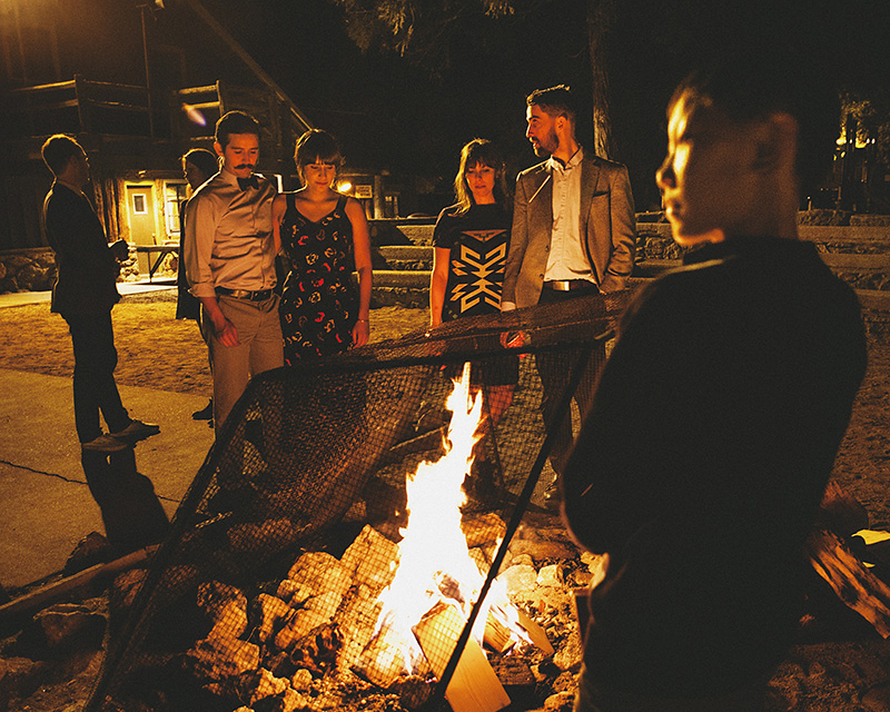 Guests gather around the fire pit at night | Kate & Will's Camp Seely Wedding | Kim Smith-Miller