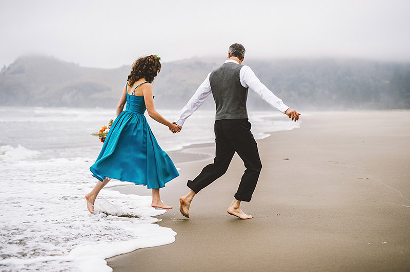 Running away from the ocean tide at Lara and Nate's Camp Westwind wedding