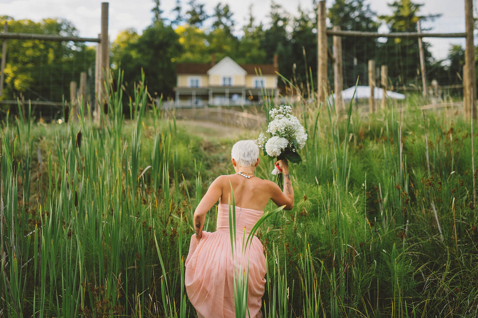 Bride climbing uphill to an Orcas Island wedding reception