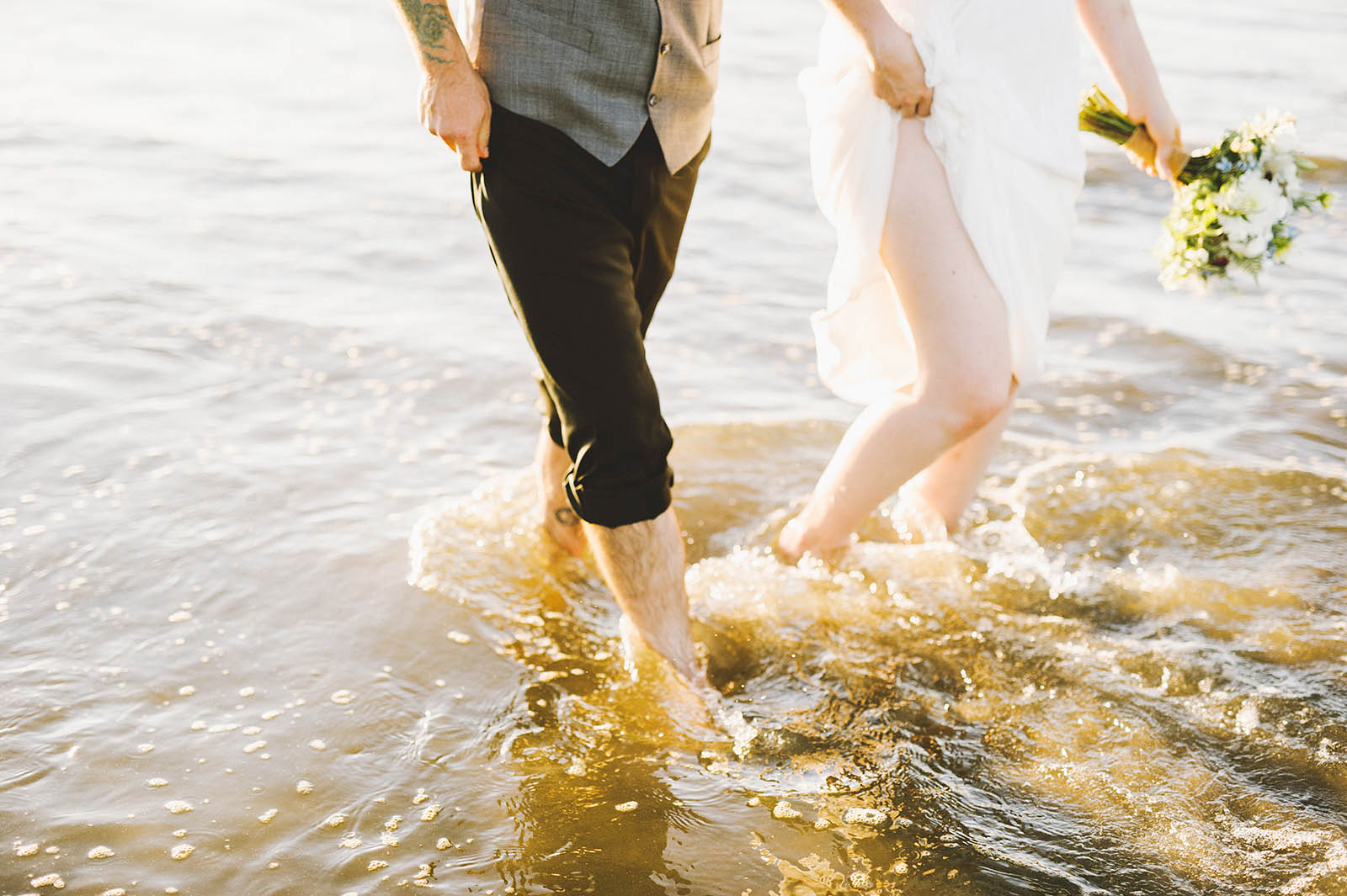 Bride and groom walking barefoot in the ocean | SouWester Lodge Wedding
