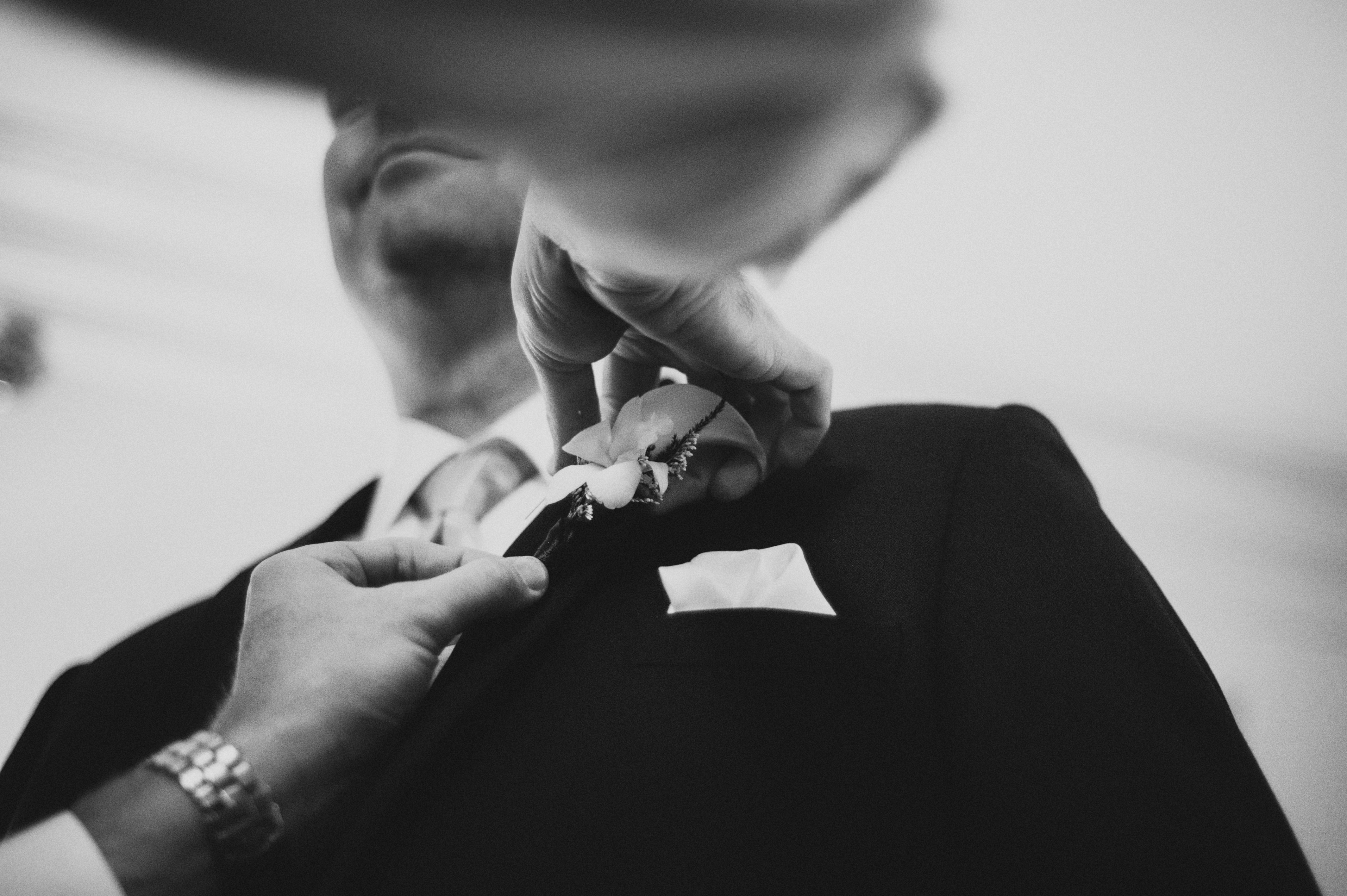 Groom putting on boutonniere | Sacramento Firehouse Wedding