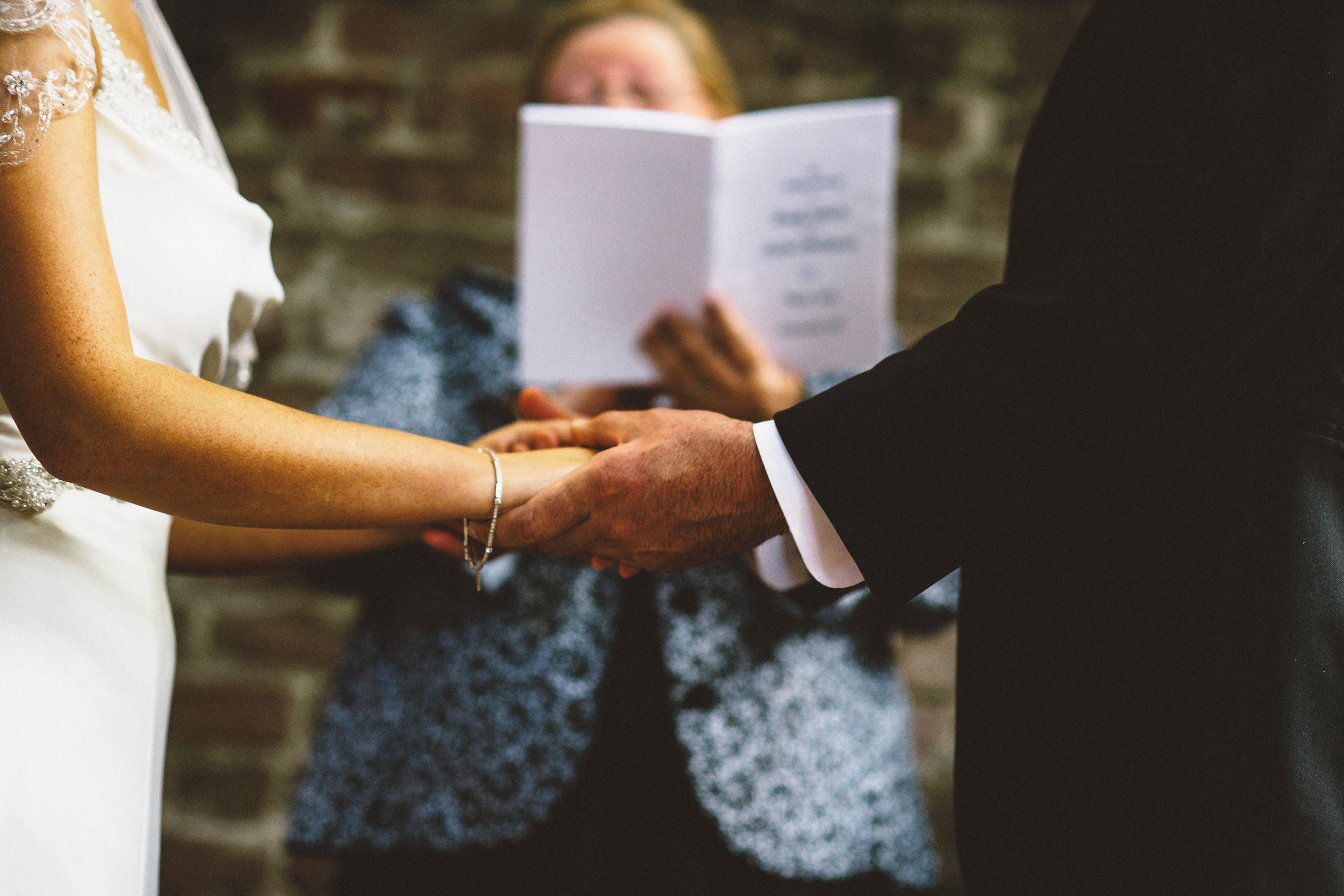 Bride and Groom holding hands at ceremony | Sacramento Firehouse Wedding