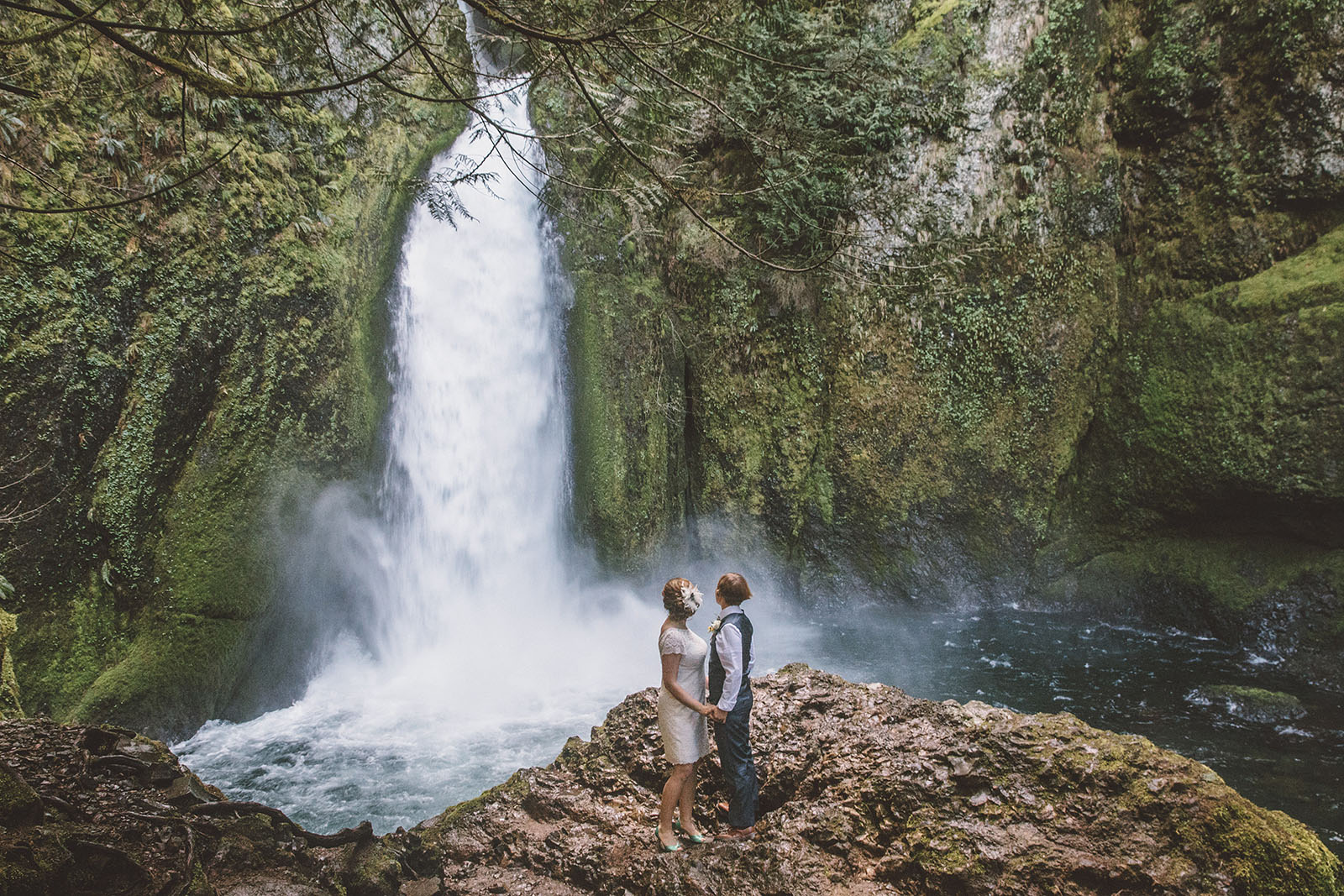 Brides holding hands at ceremony site | Wahclella Falls Wedding