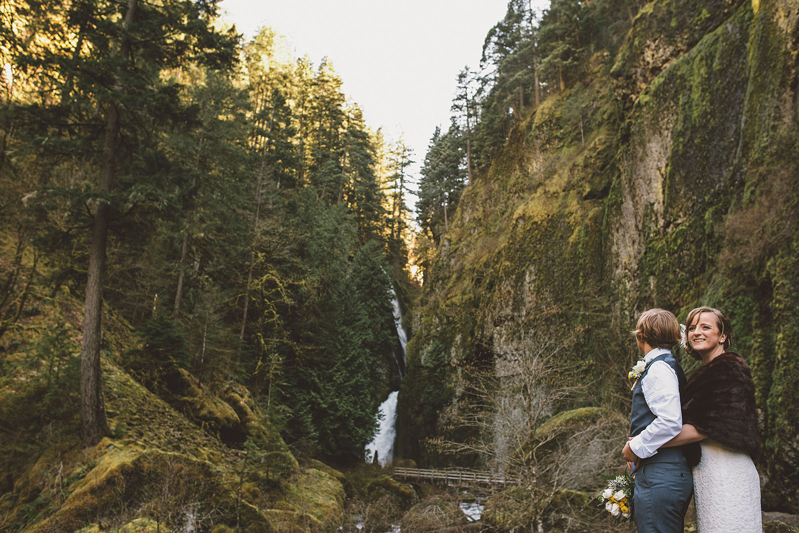 Brides hugging over Tanner Creek | Wahclella Falls Wedding