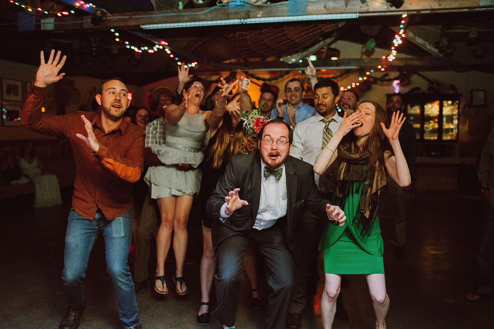 Guests jumping for the bouquet toss | Woodsy Campground Wedding