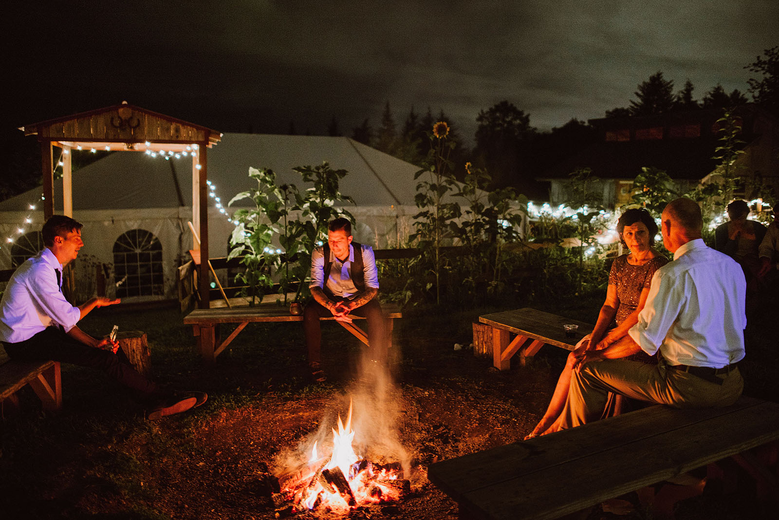 Guests huddled around the pit fire at Pendarvis Farm | Woodsy Campground Wedding