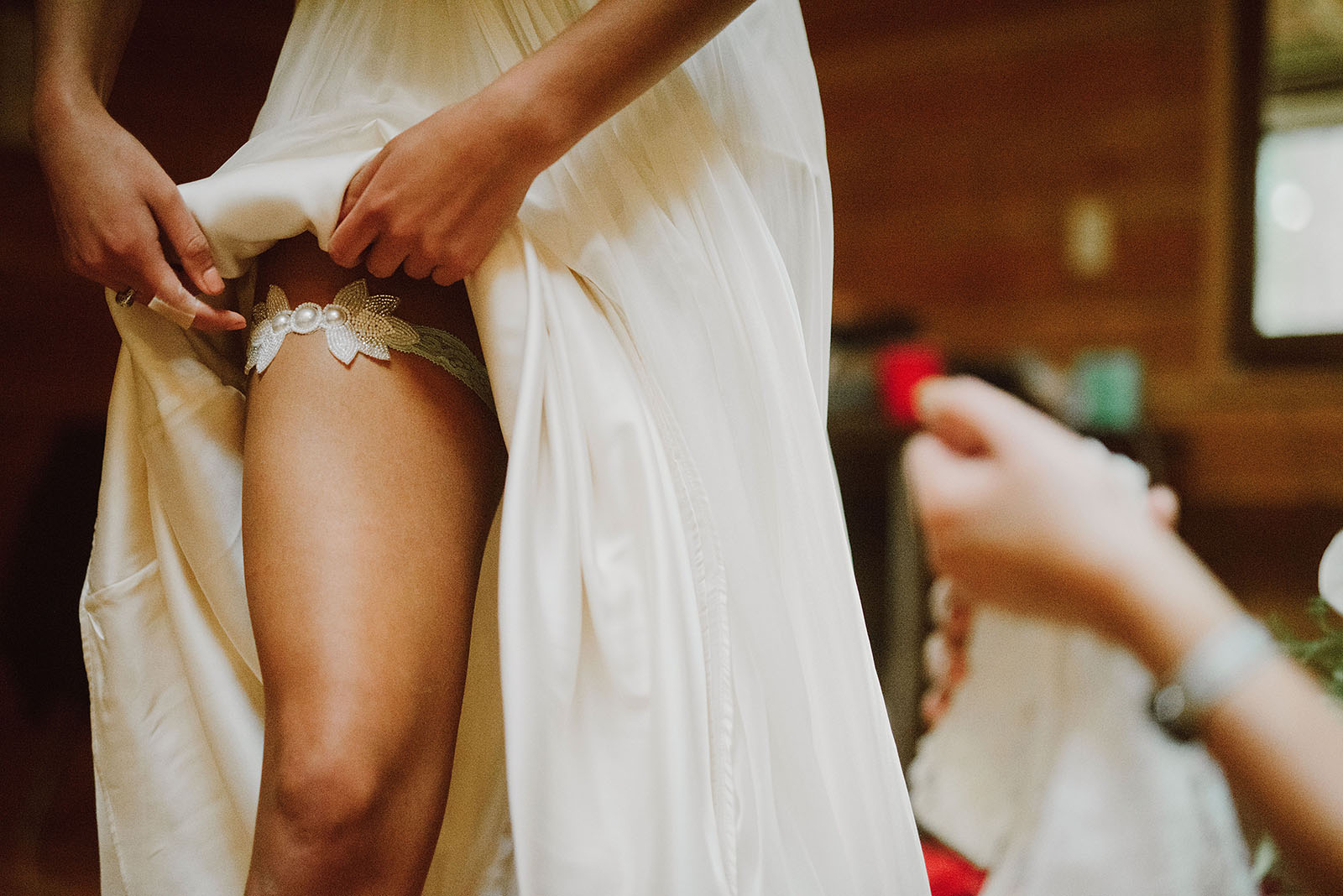 Bride putting on garter for her Camp Namanu wedding