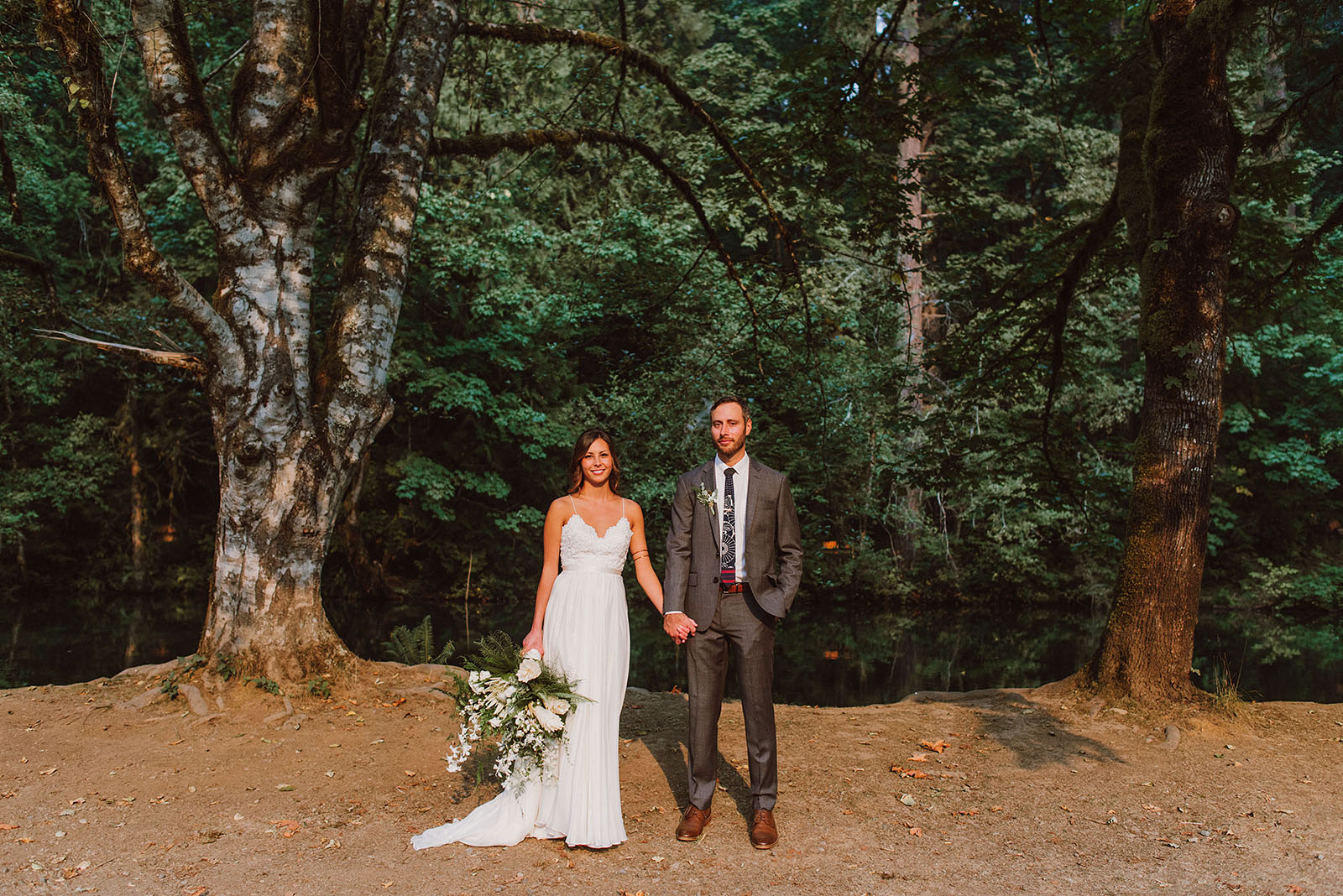 Bride and Groom posing in front of the pond at a Camp Namanu wedding