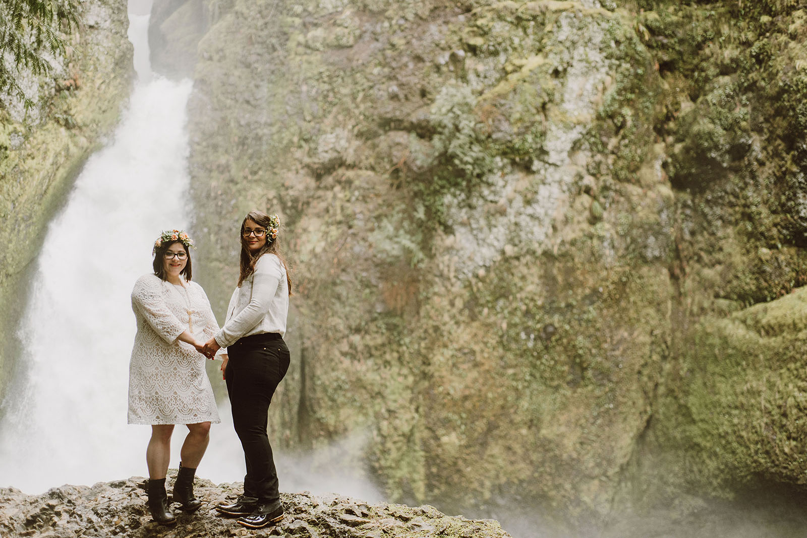 brides holding hands in front of Wahclella Falls - Portland Wedding photography