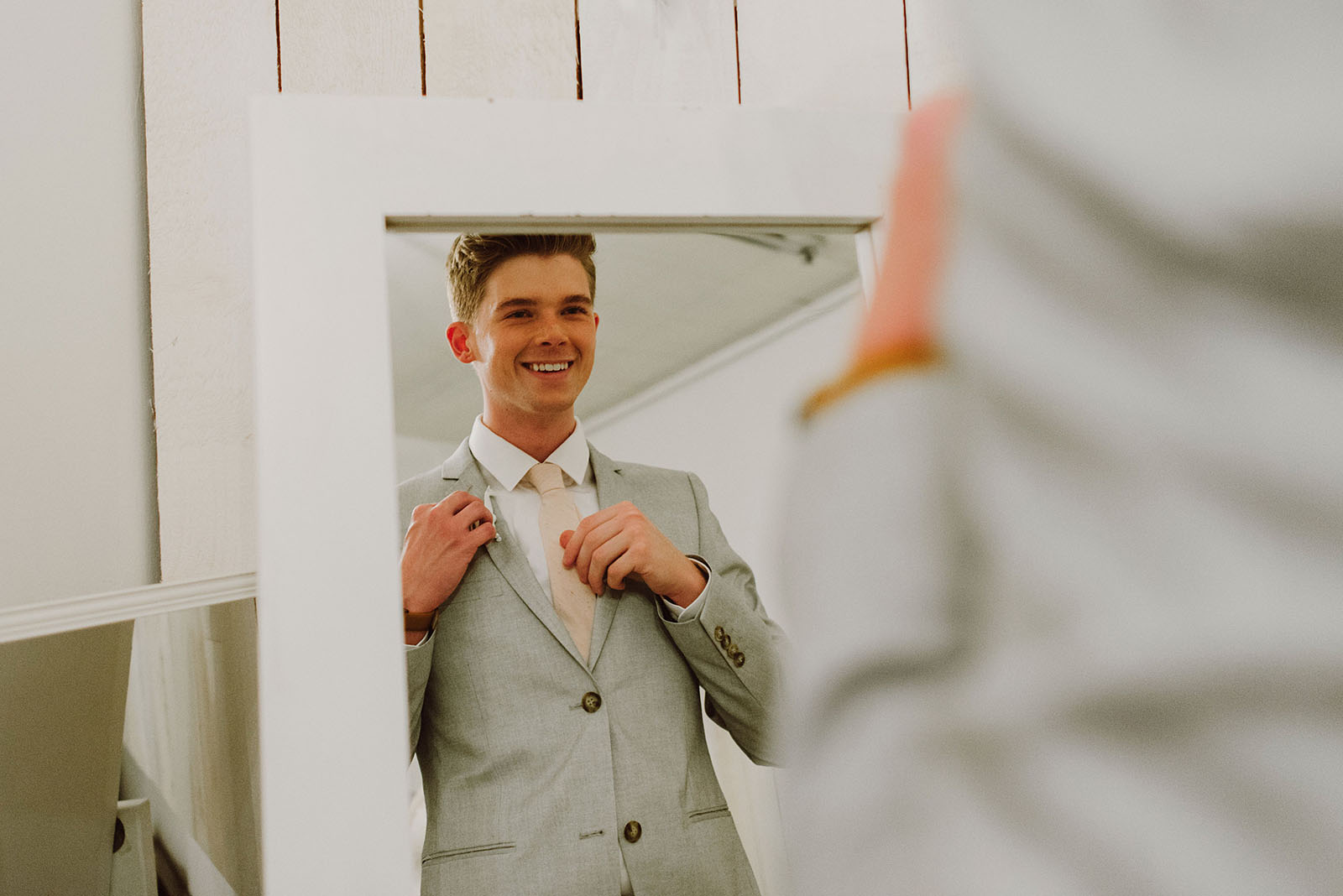 Groom looking in mirror at Union Pine wedding