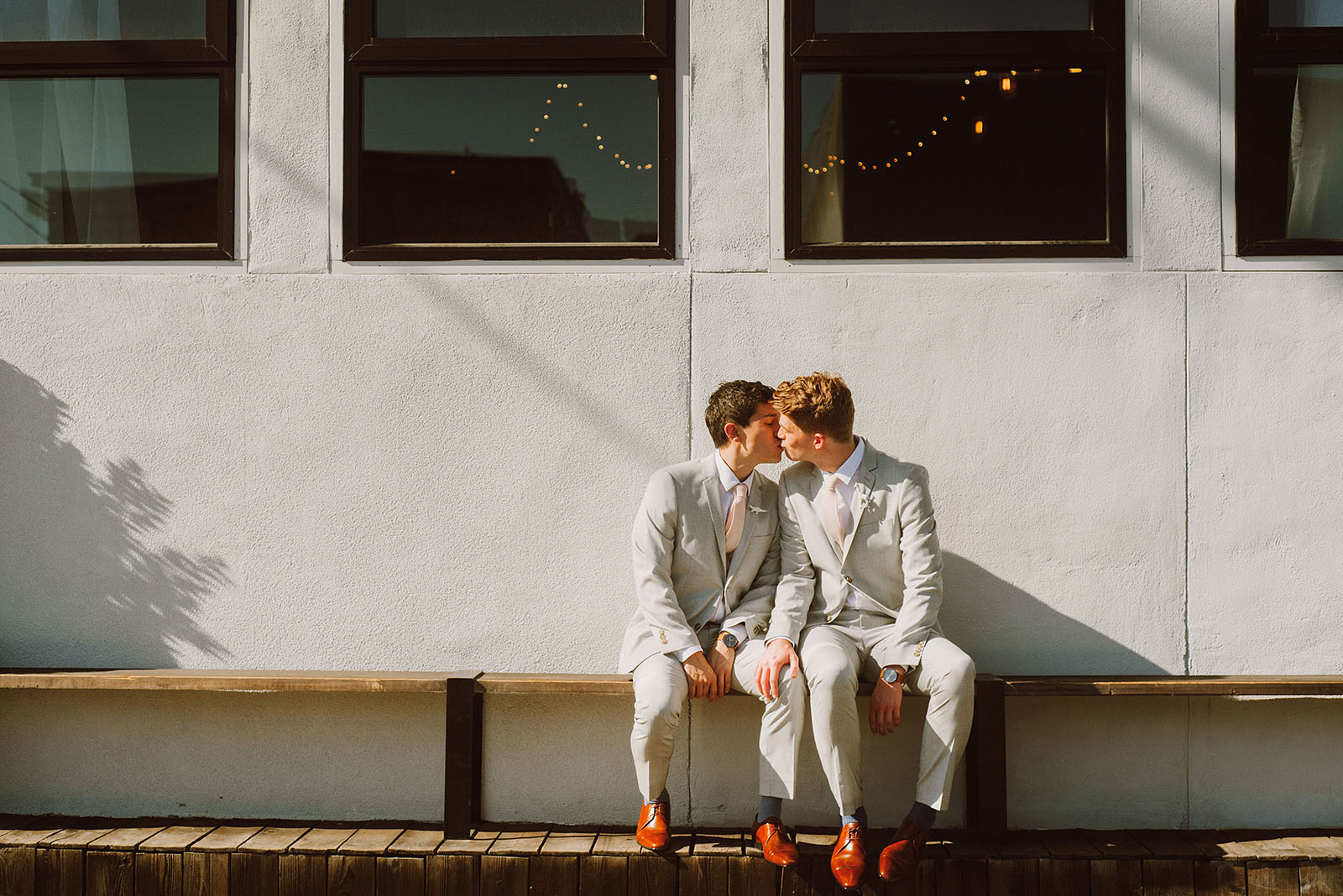 Grooms kissing outside of Union Pine