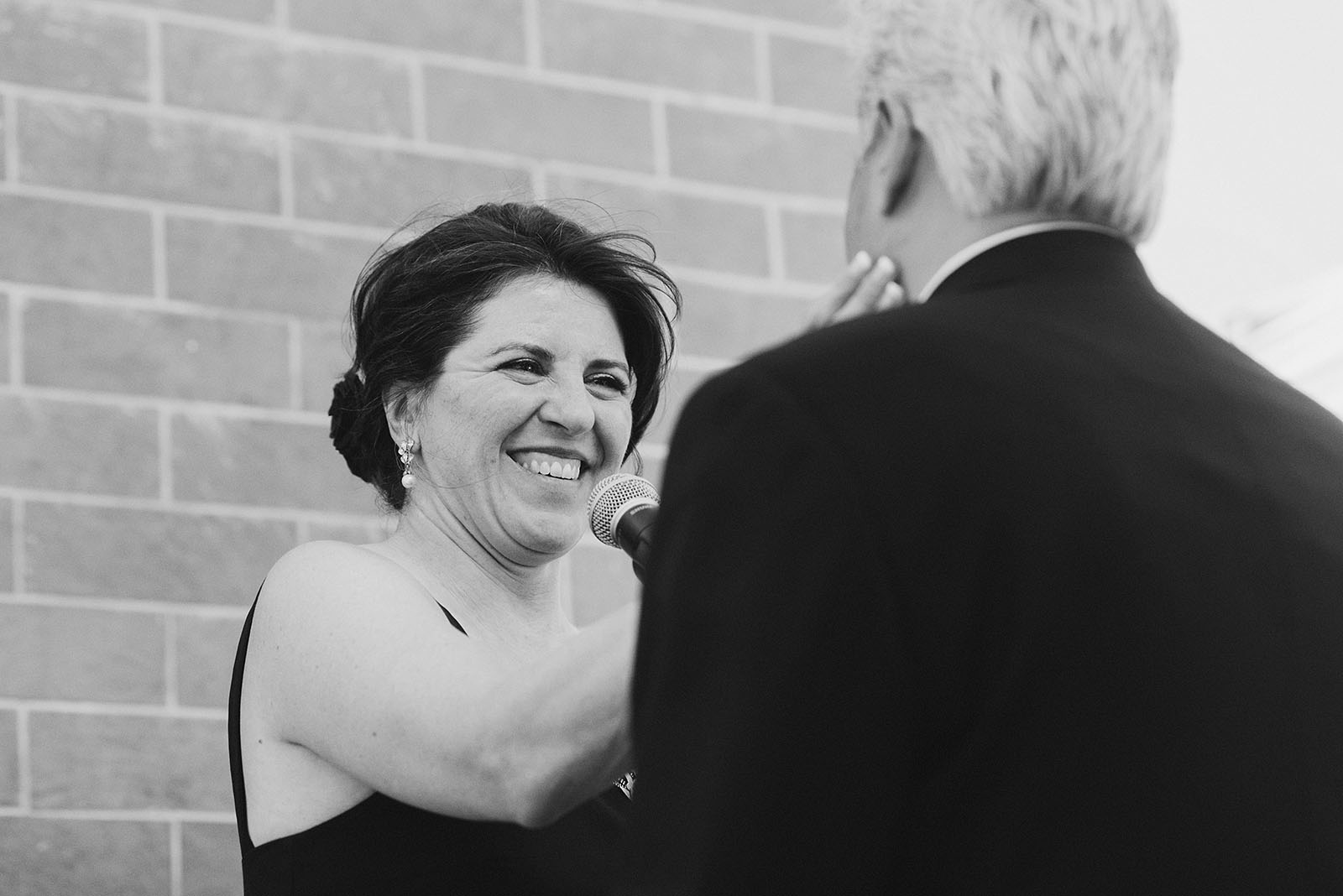 Bride embraces Groom's face at their Ecotrust Wedding ceremony