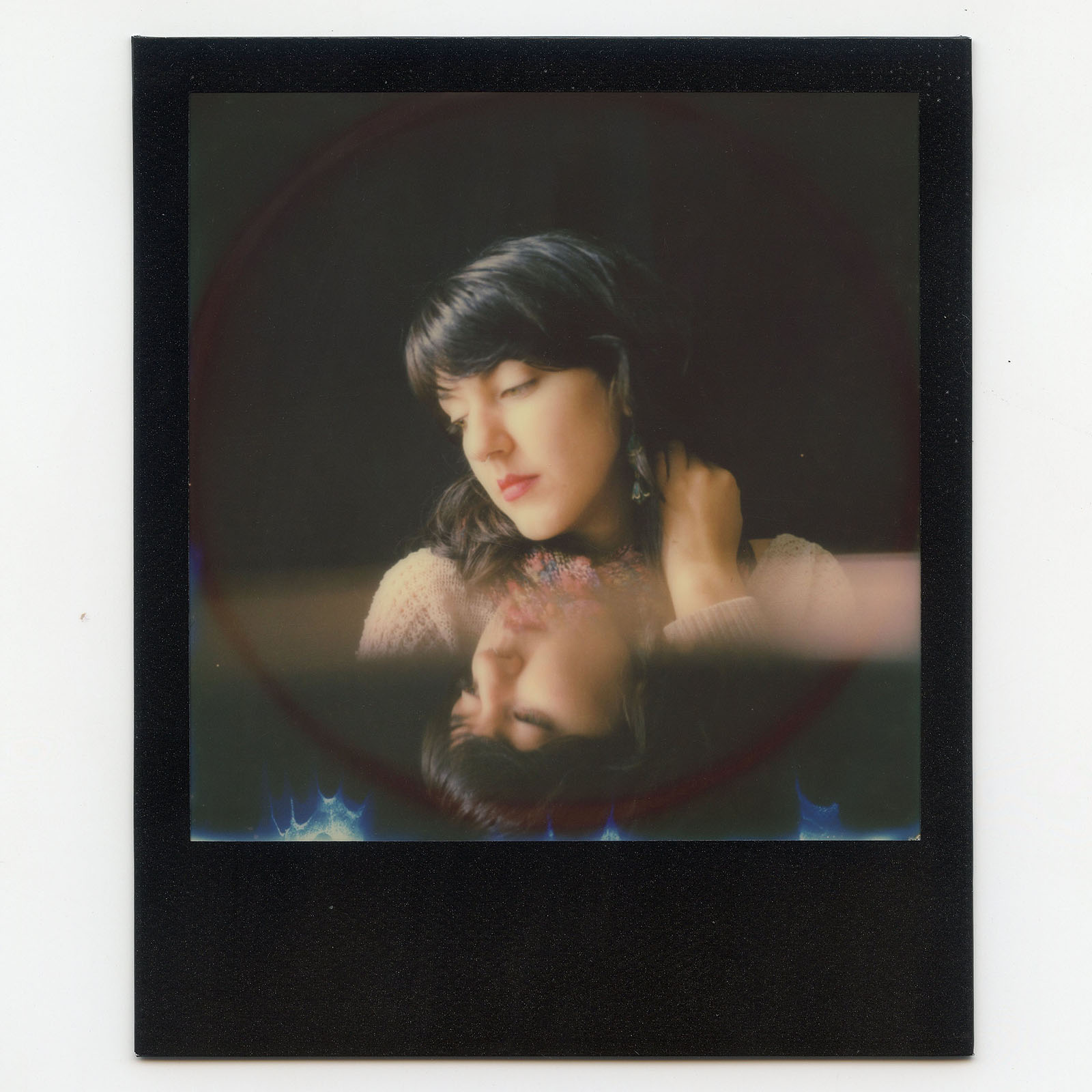 Polaroid portrait of a woman with her reflection