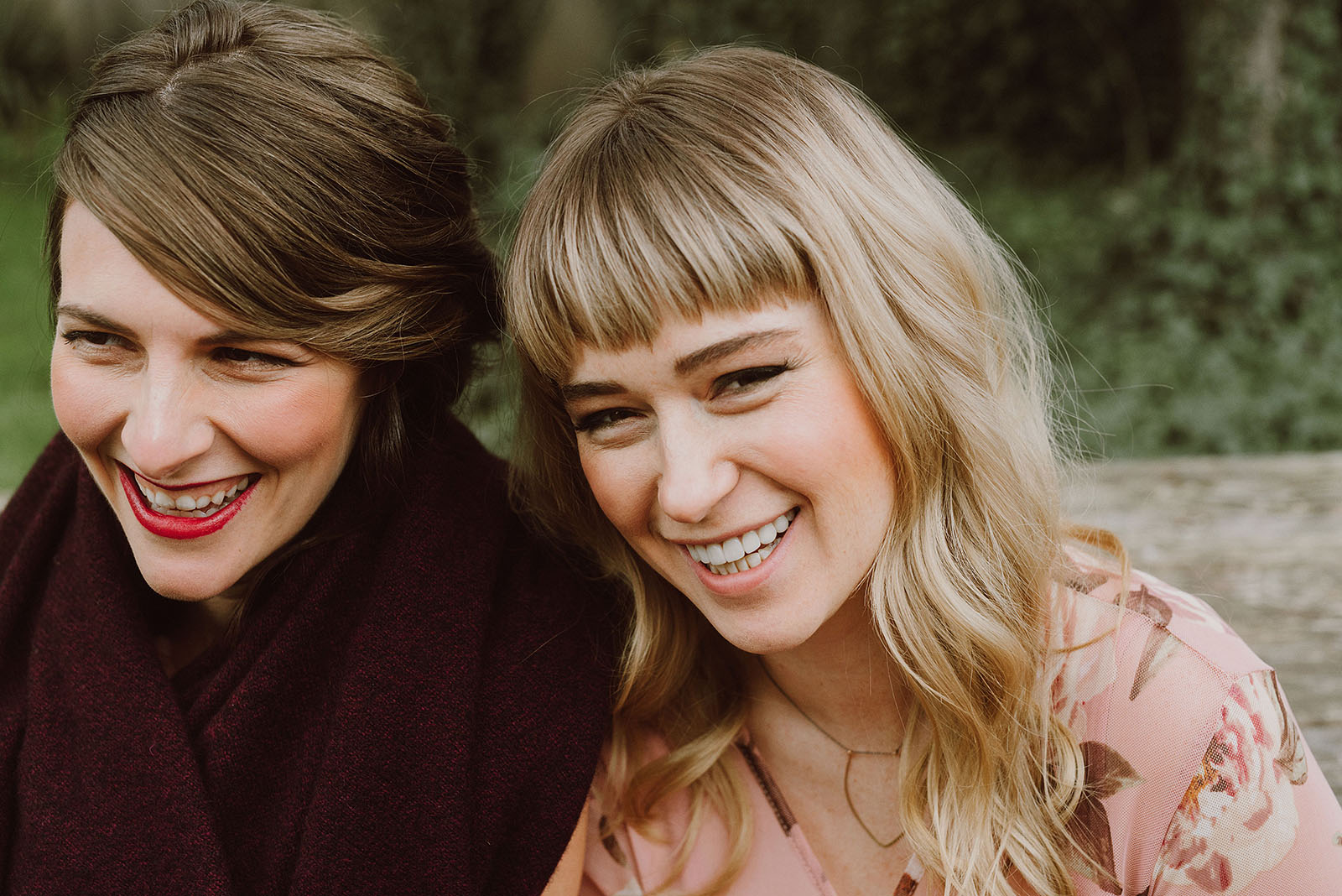 Portland Bridal Photography - Bride and bridesmaid giggling while sitting on a picnic table