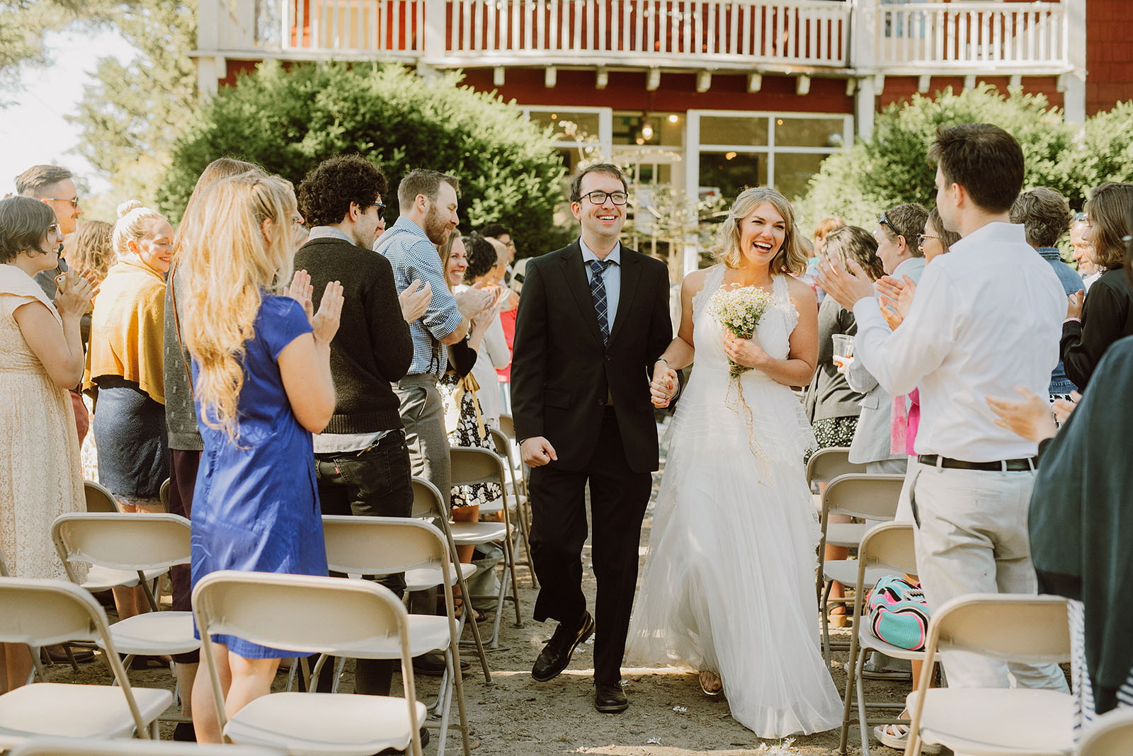 Bride and Groom smiling as they leave the ceremony together at a SouWester Wedding in Seaview, WA