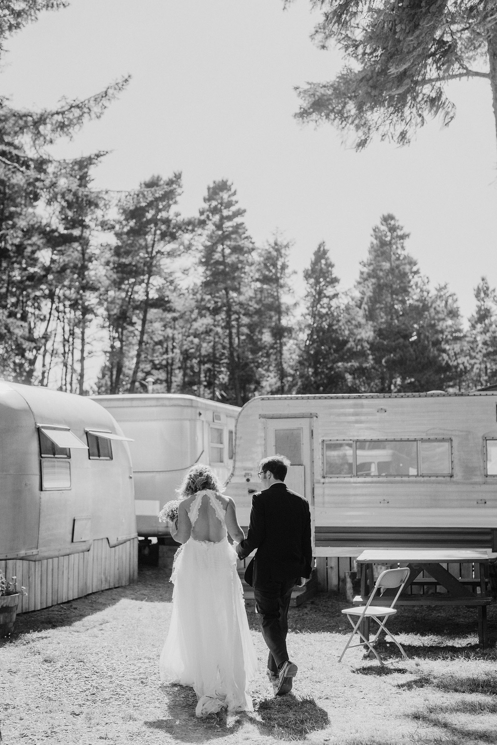 Bride and Groom walking behind the trailers at a SouWester Wedding in Seaview, WA