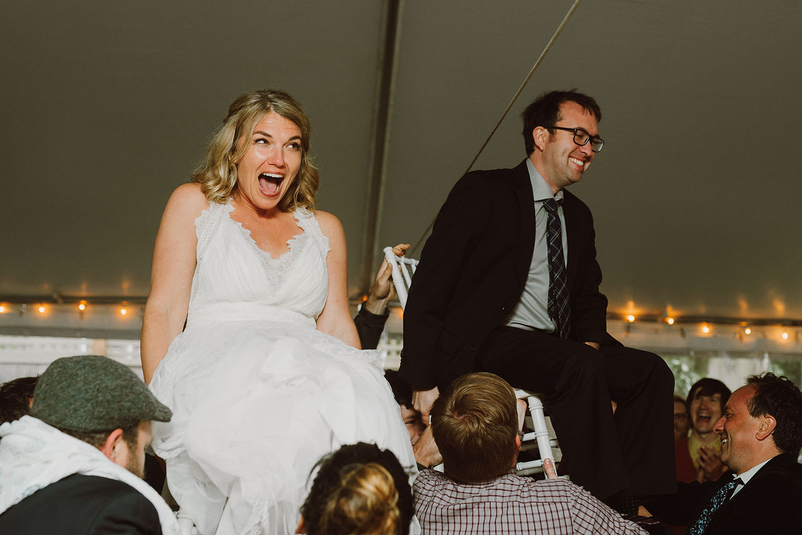 Bride and Groom being lifted by guests during the hora at a SouWester Wedding in Seaview, WA