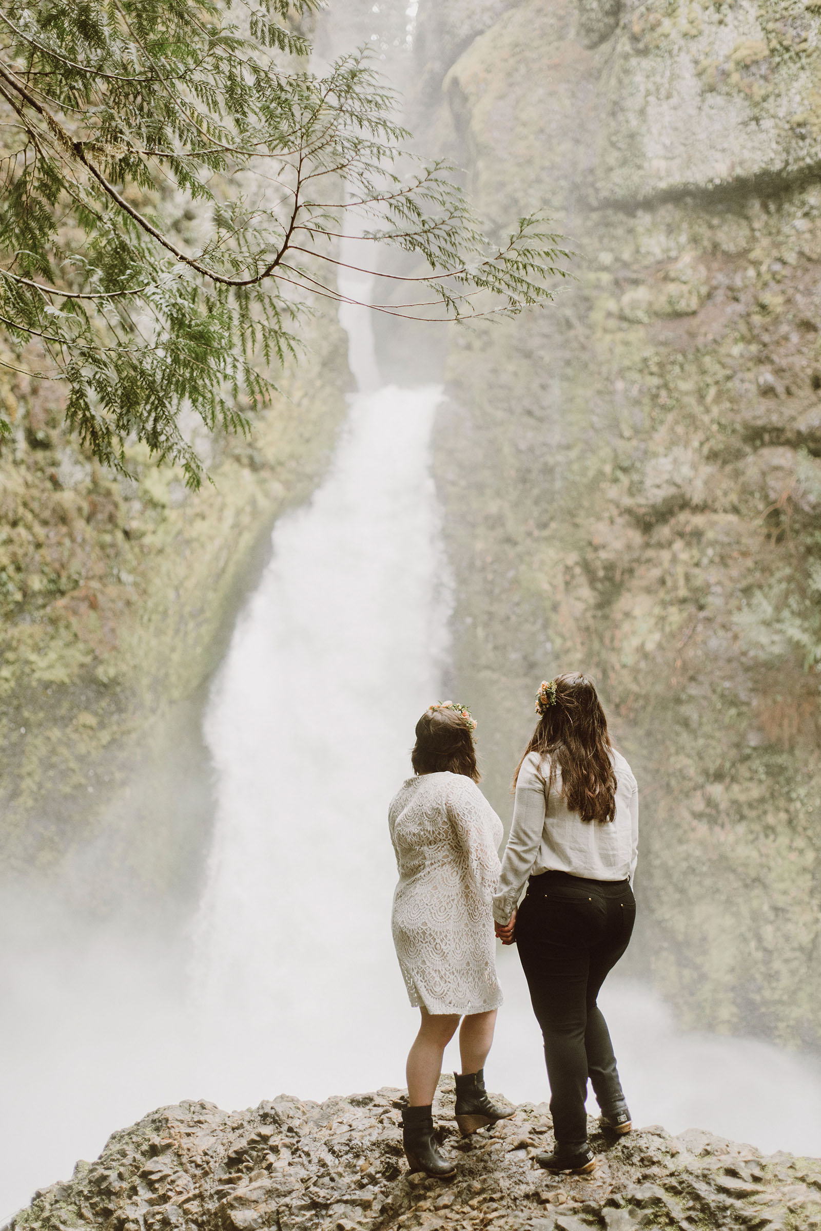 Brides posing in front of Wahclella Falls at a Portland waterfall elopement