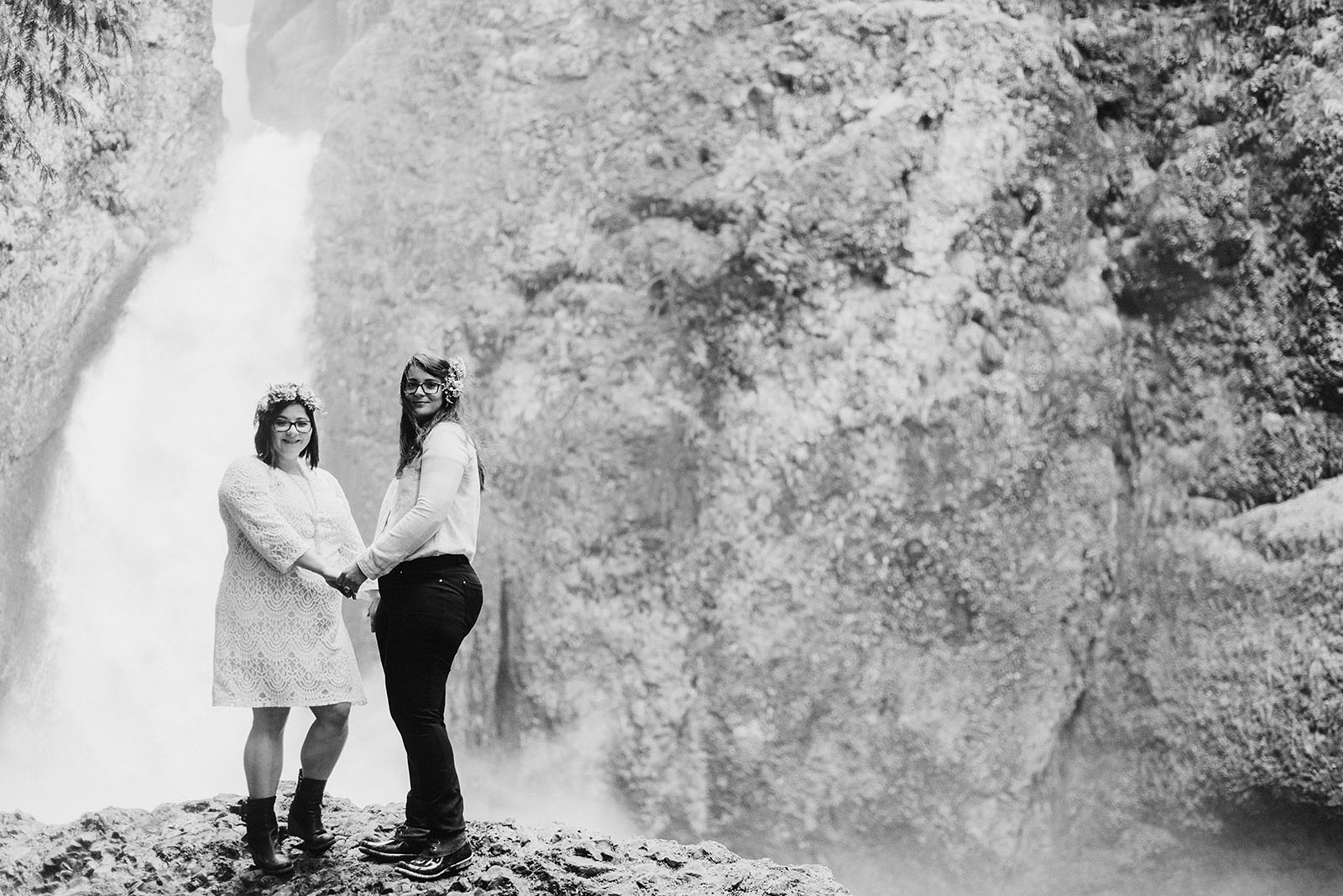 Brides posing in front of Wahclella Falls at a Portland waterfall elopement