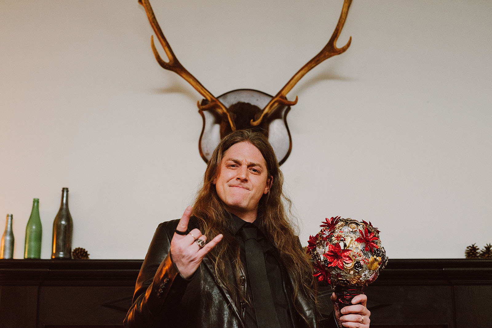 Groom making hand horns while holding the bouquet at The Colony St Johns Wedding