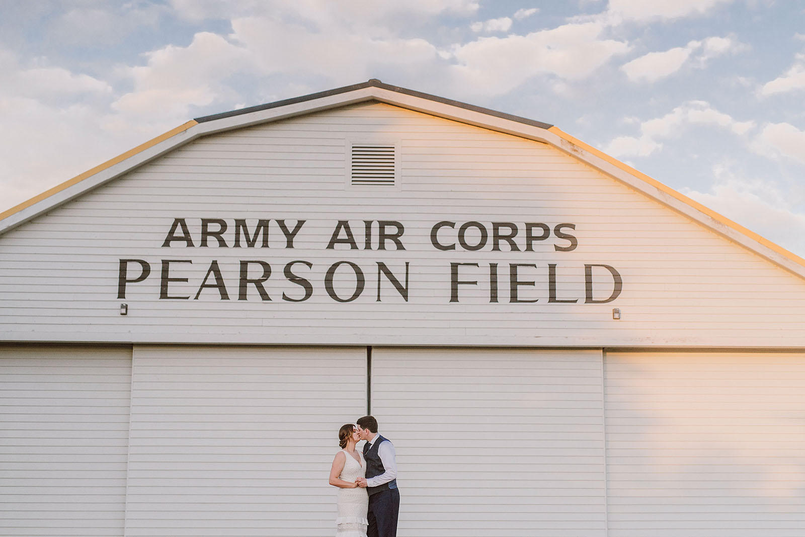 bride and groom standing under the Pearson Field barn in Vancouver - portland wedding photography