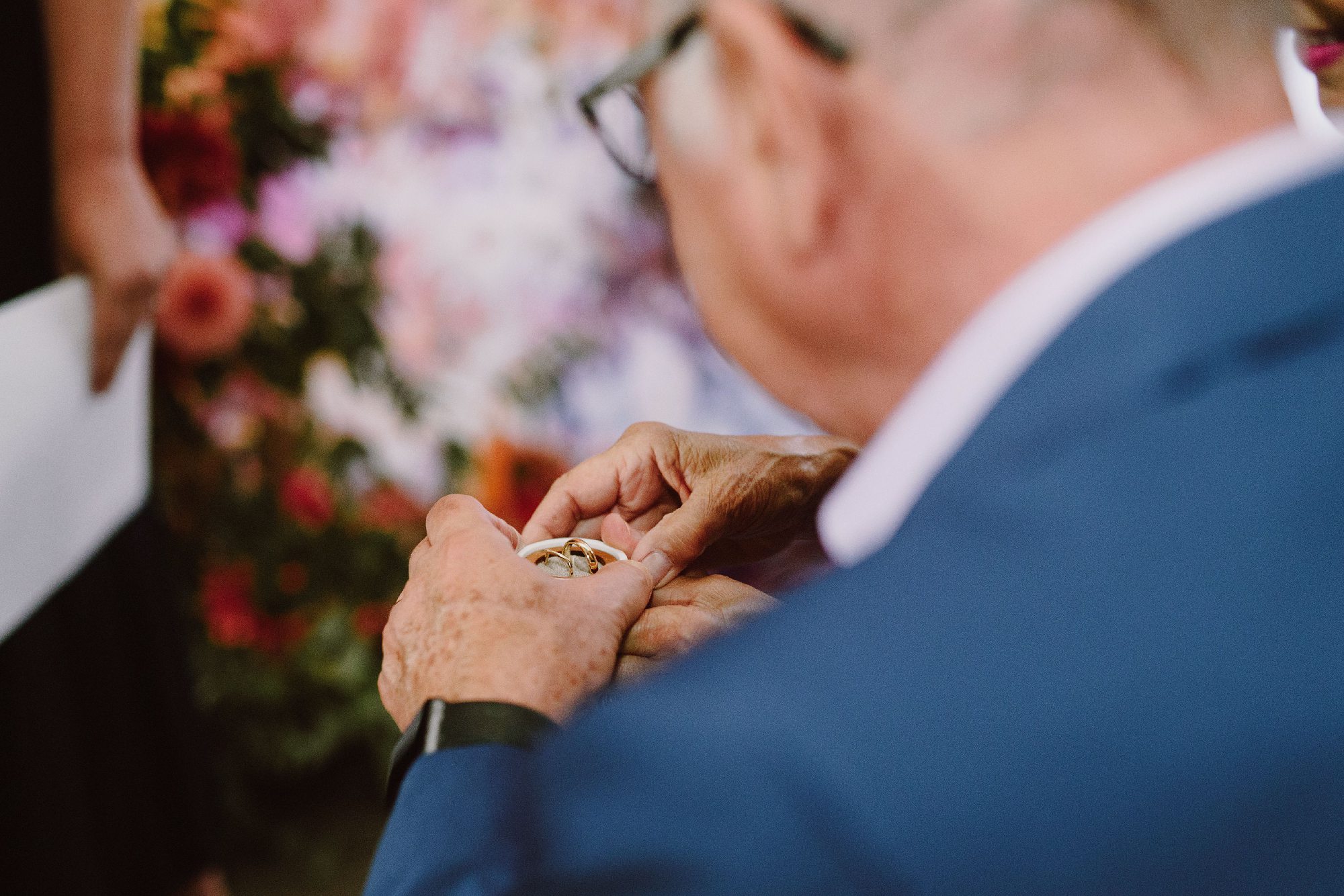 Elderly wedding guest holding rings while blessing them