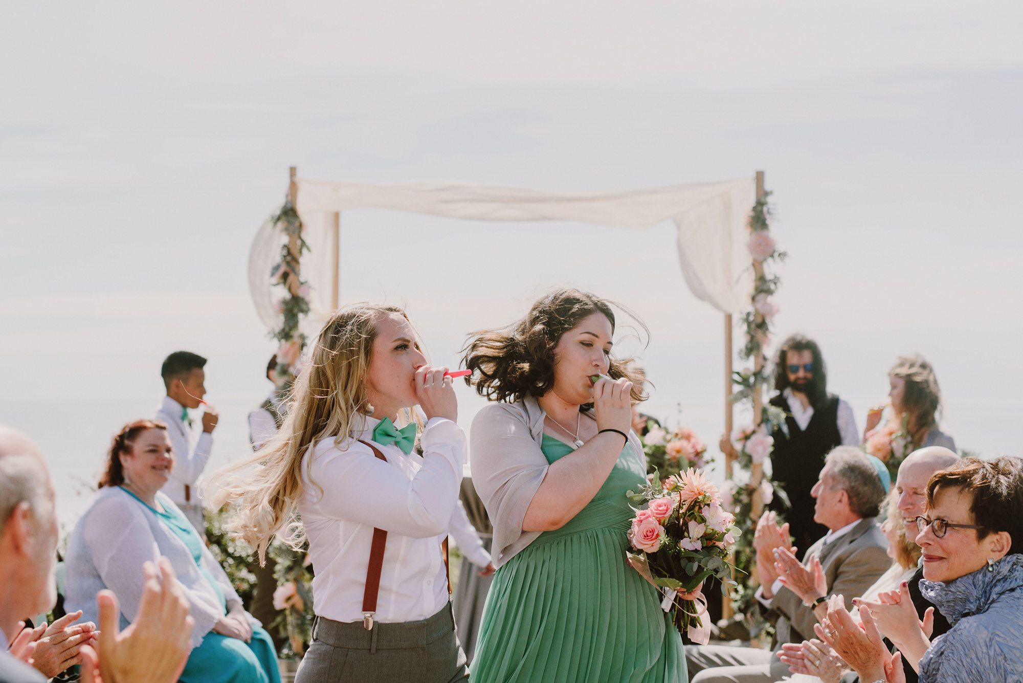 Wedding party playing kazoos as they leave the ceremony