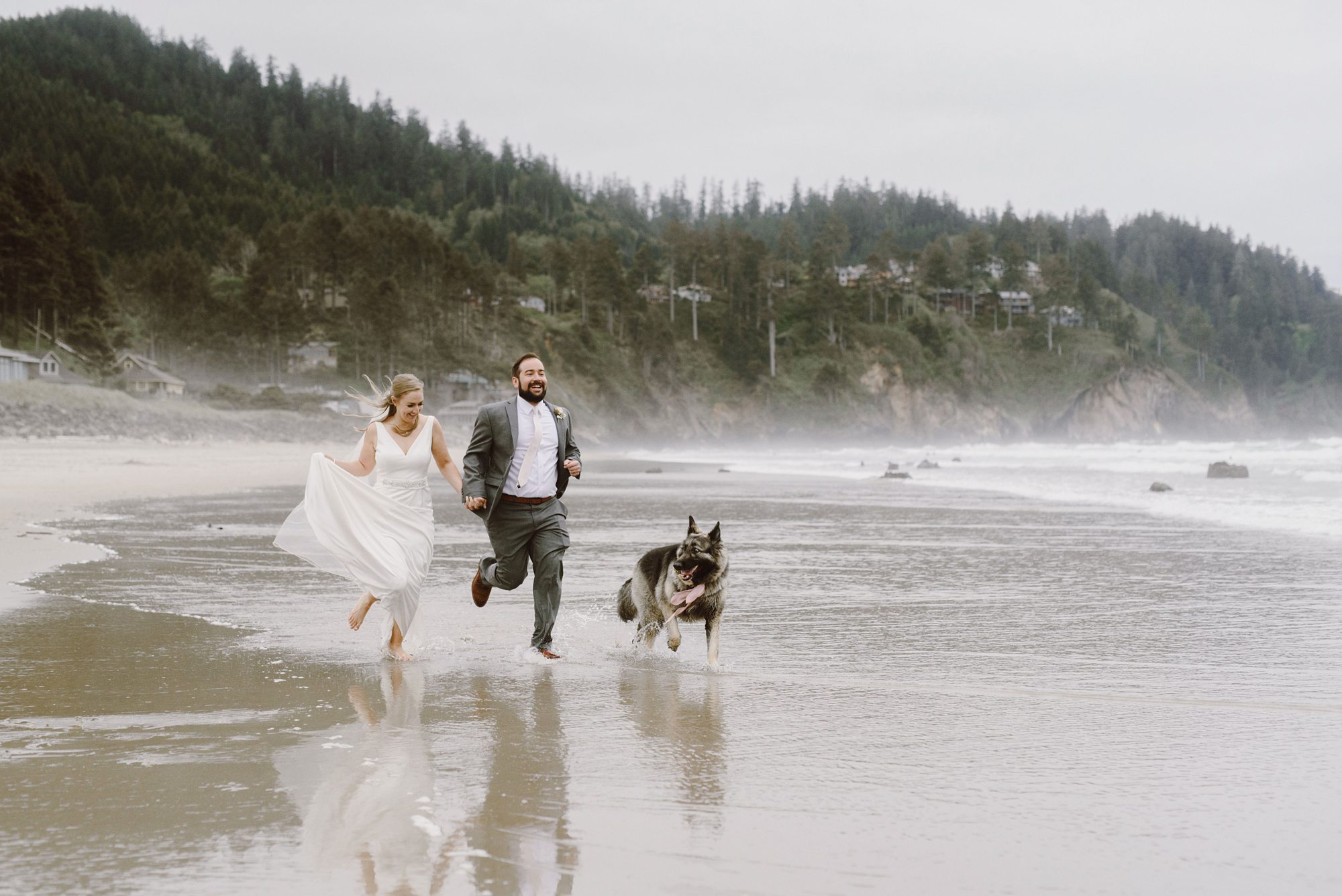Newlyweds running down the beach with their dog | Portland Wedding Photographer