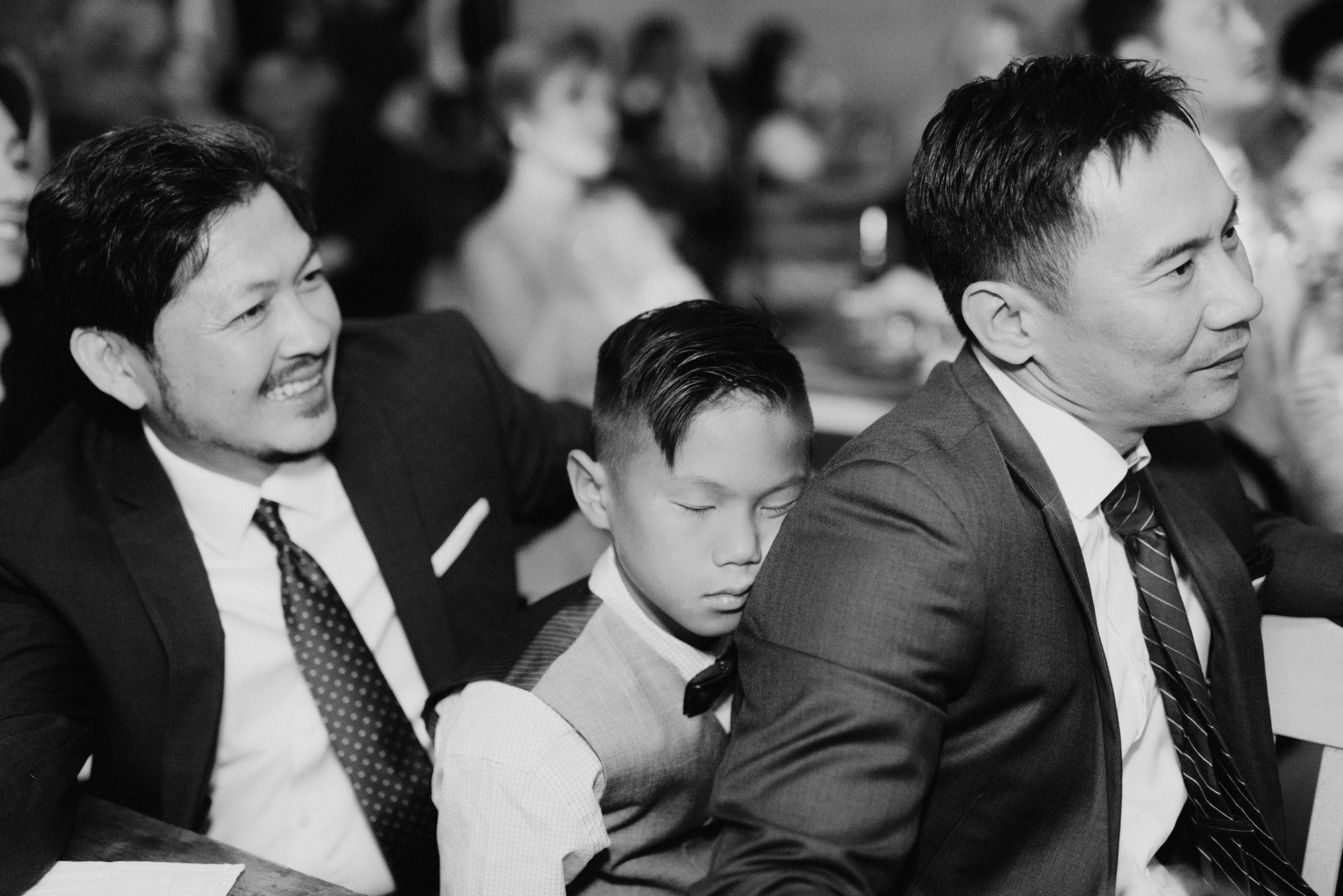 Child falling asleep while leaning on wedding guests at Foreign Cinema in San Francisco, CA