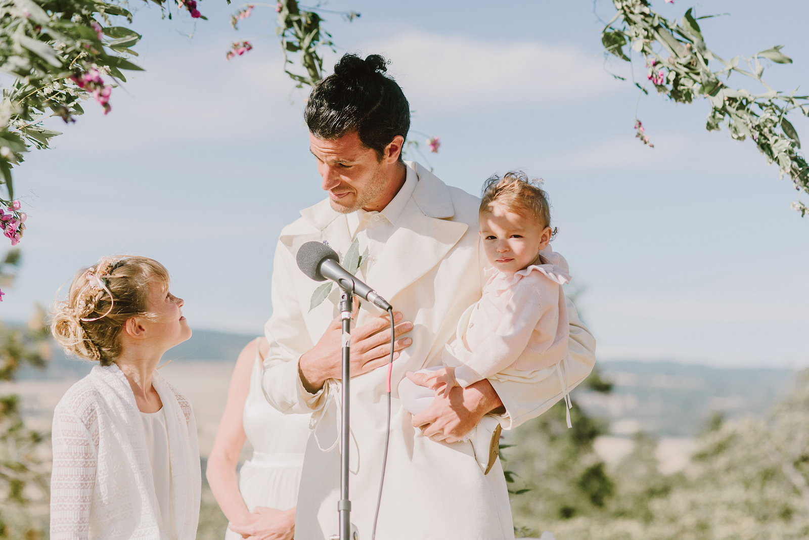 Groom holding his newborn baby while exchanging vows with his daughter - Columbia River Gorge wedding