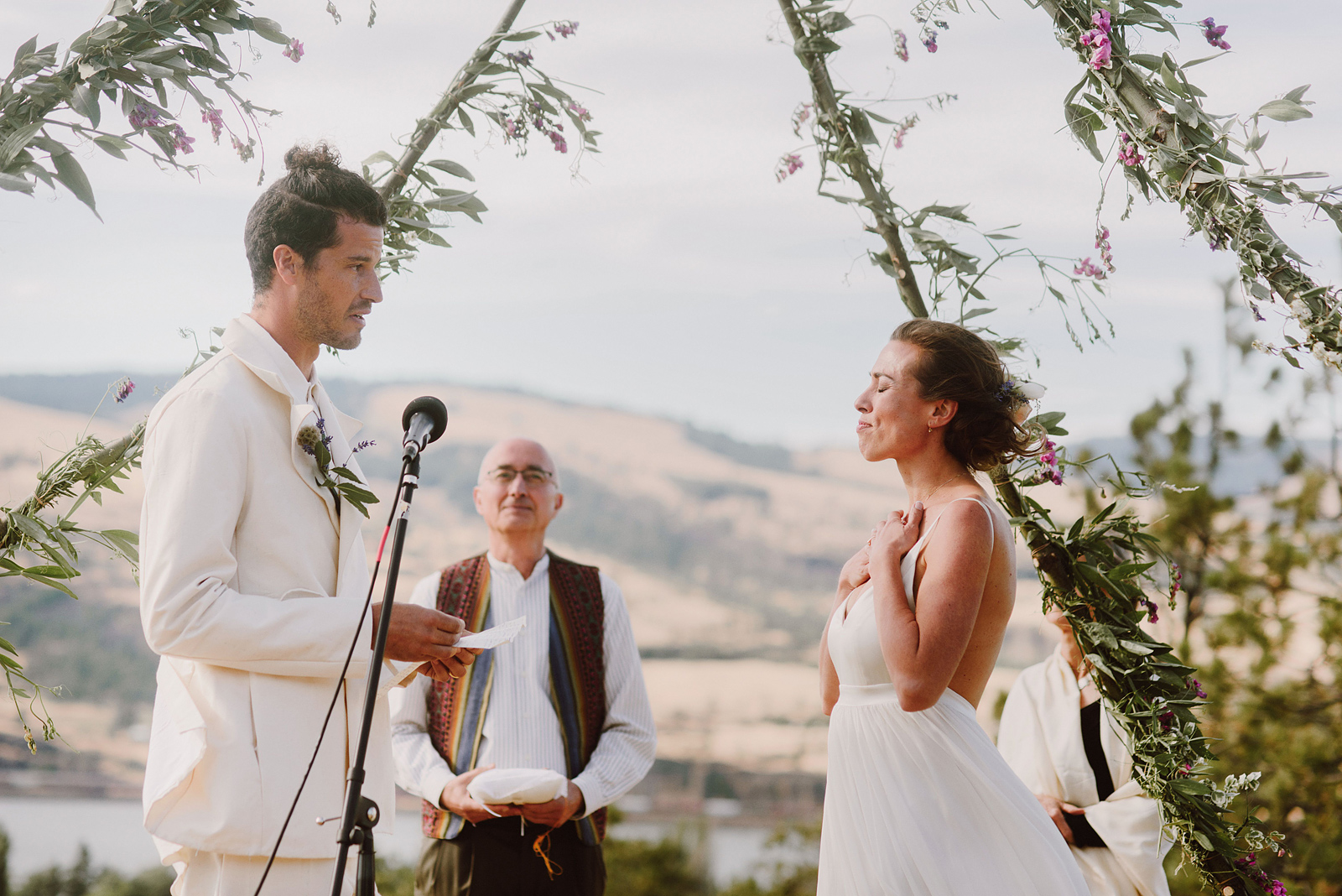 Bride holding her hand to her heart while the groom reads his vows - Columbia Gorge River Wedding in Oregon