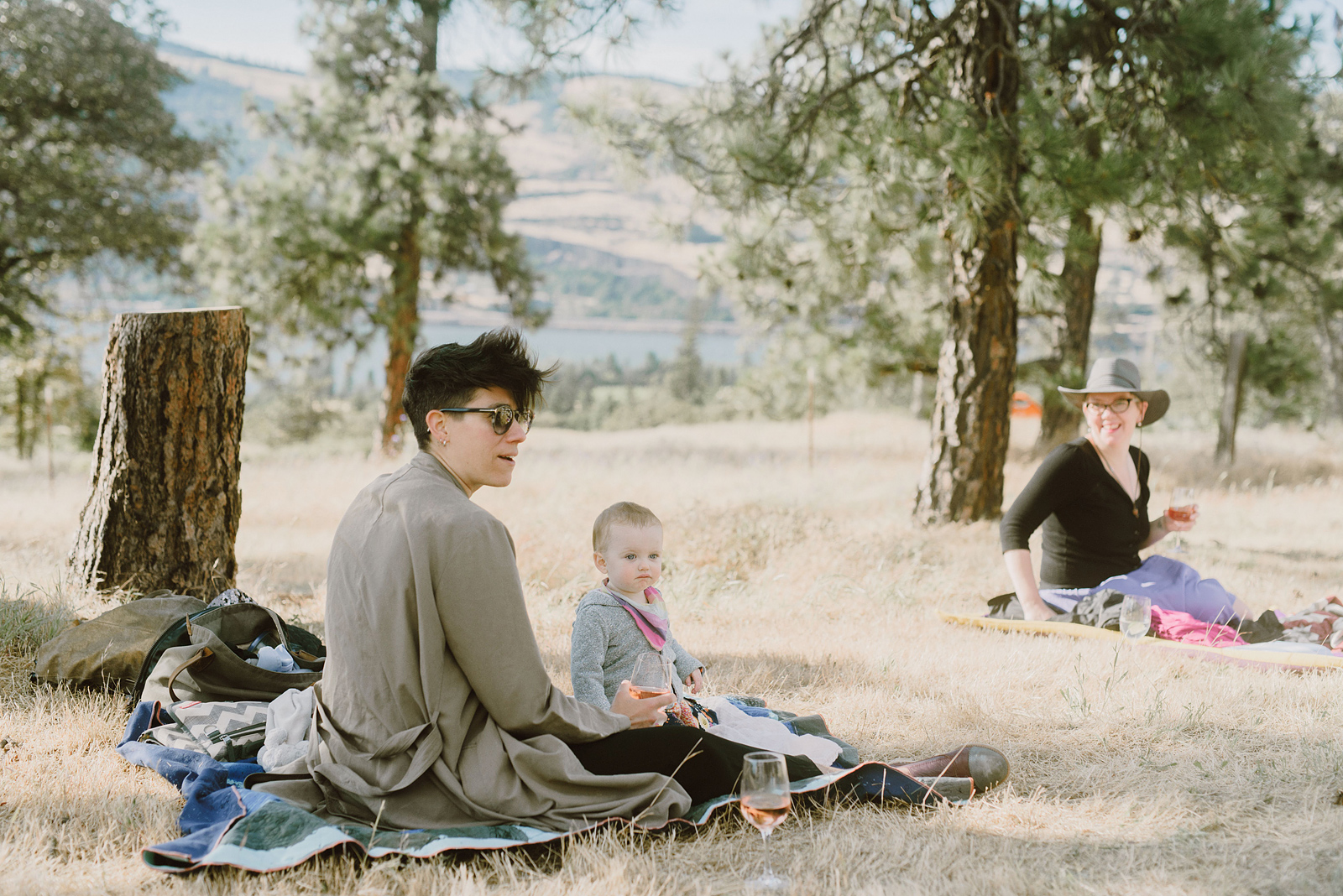 Guests sitting on blankets in an open field - Columbia River Gorge wedding reception in Mosier, OR