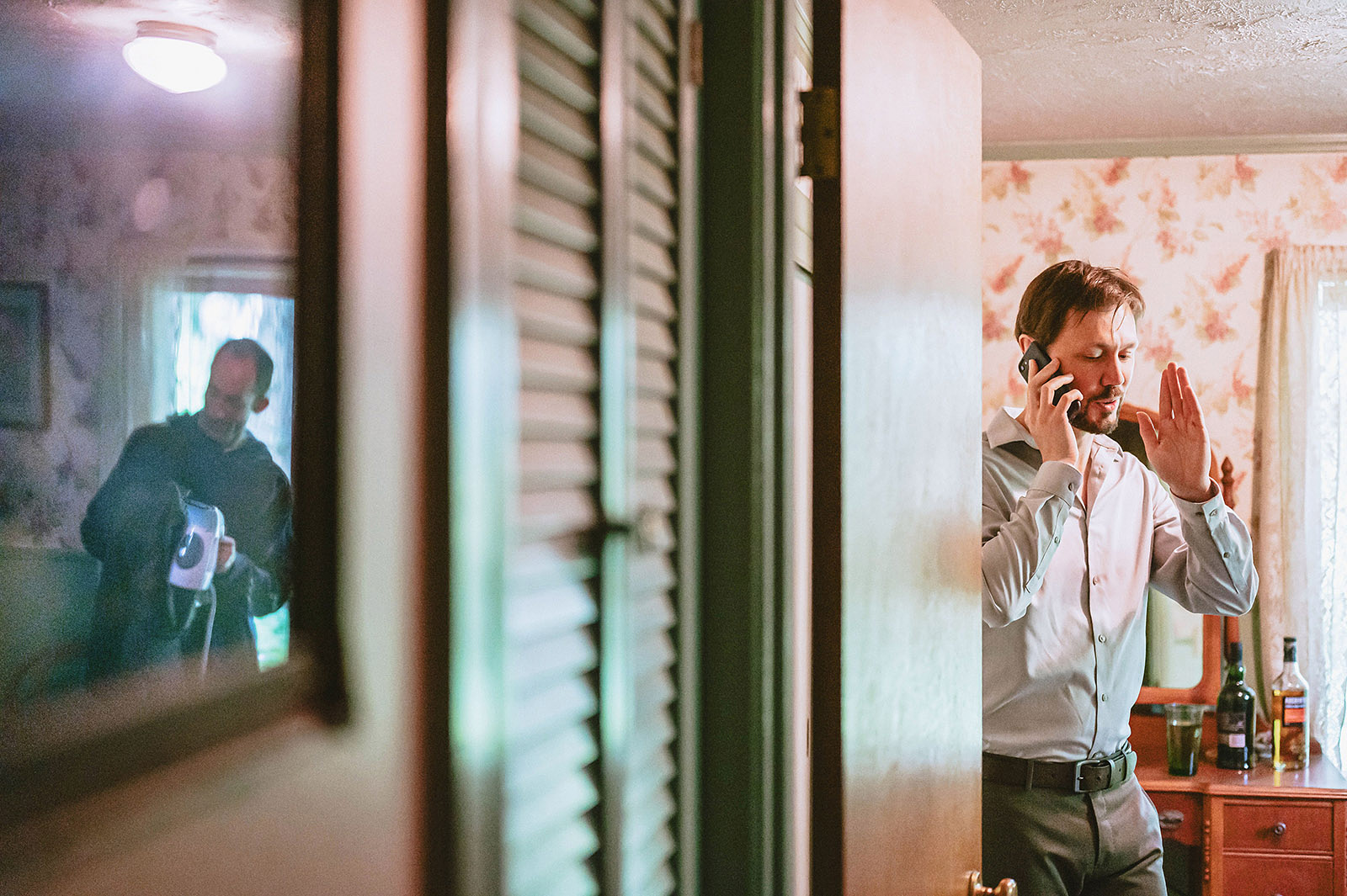 Groom talking on the phone while his friend steams his pants at Kelly's Trout Creek Inn, WA