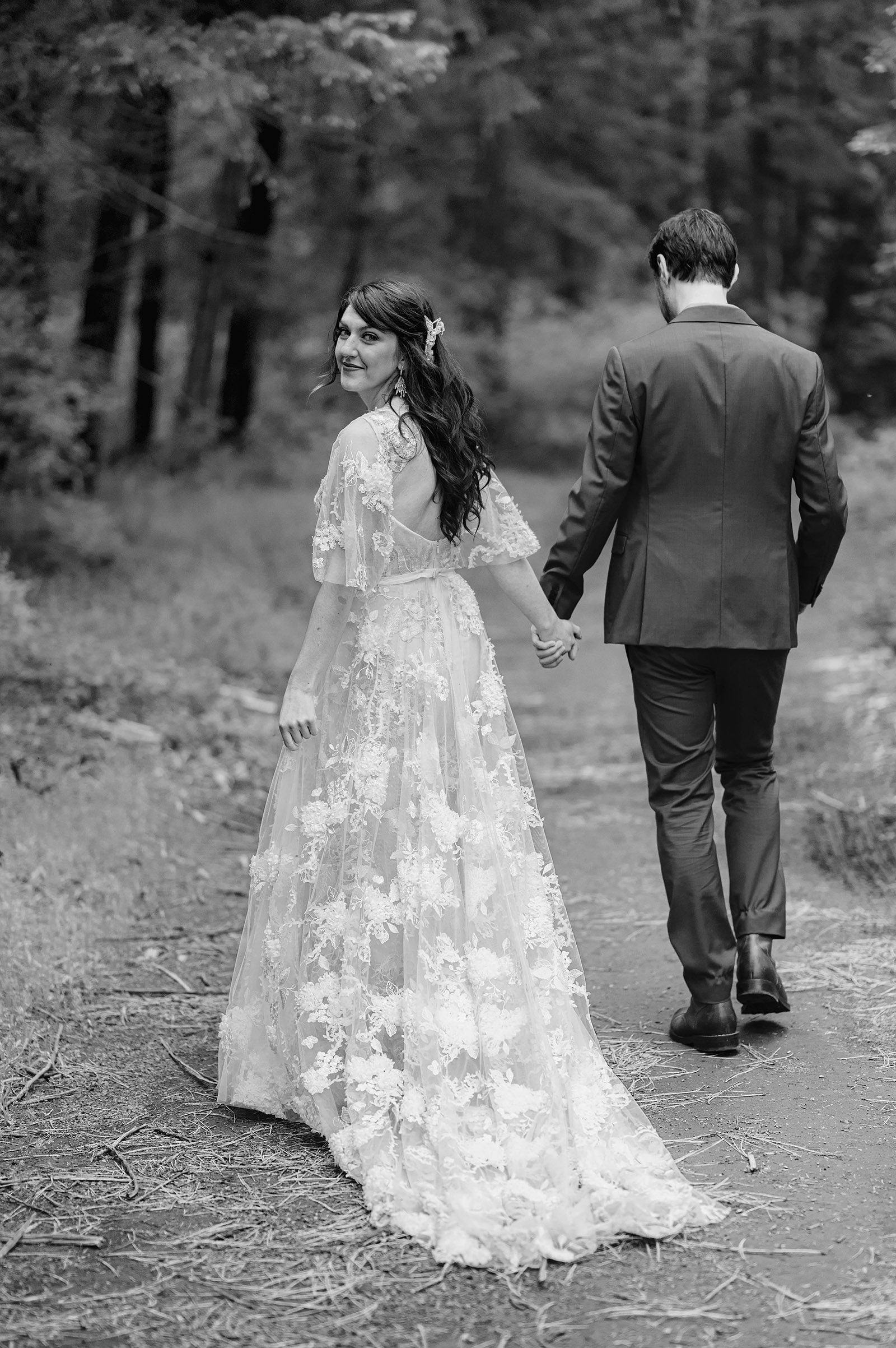 Bride looking over her shoulder as she walks away with Groom in the forest - Trout Lake Wedding, WA
