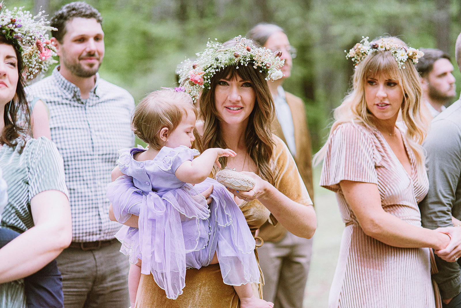 Bridesmaid holding a baby while it blesses the ceremonial rings - Trout Lake Wedding, WA