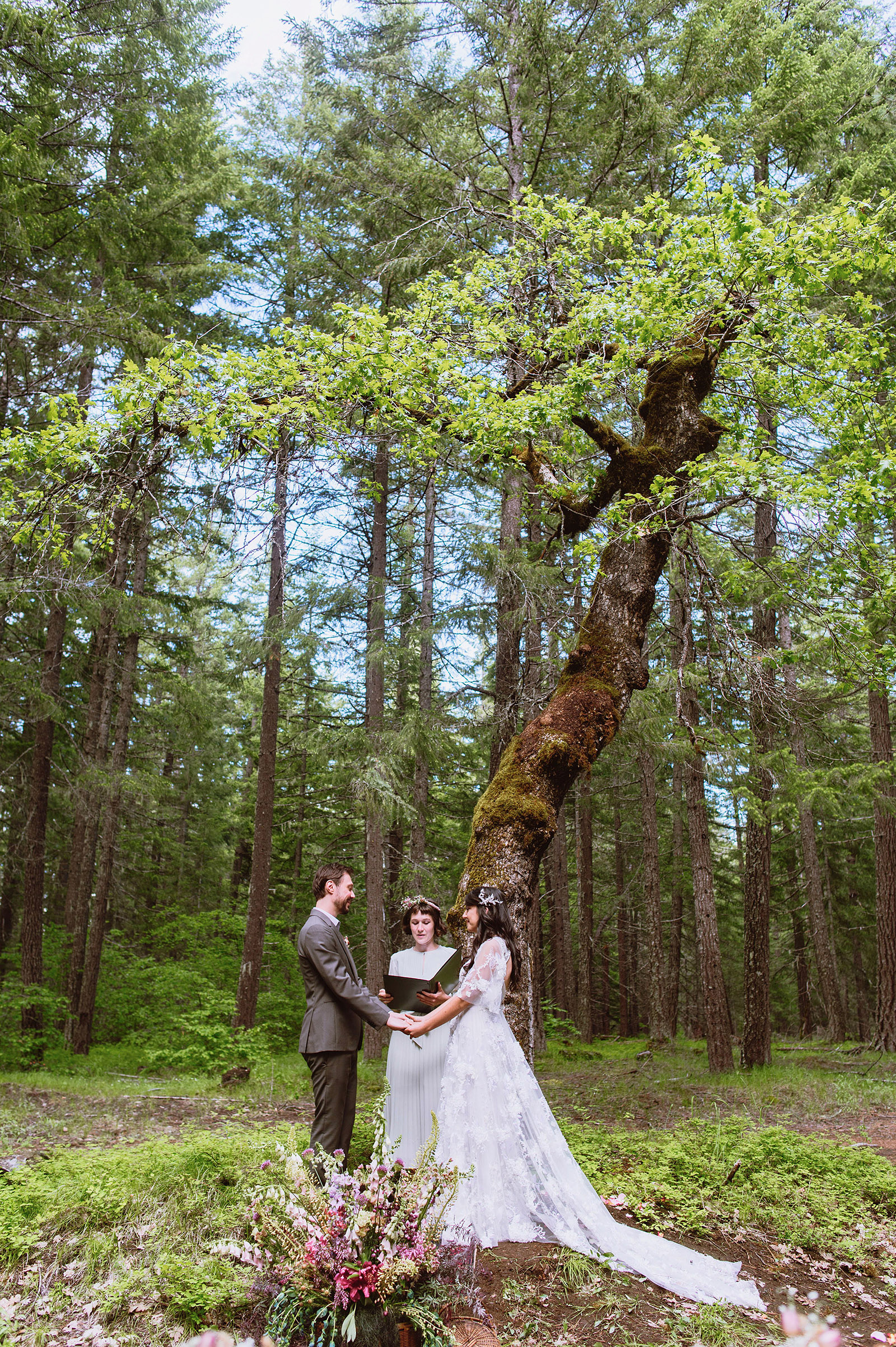 Bride and groom exchanging vows at the base of a tree - Trout Lake Wedding, WA
