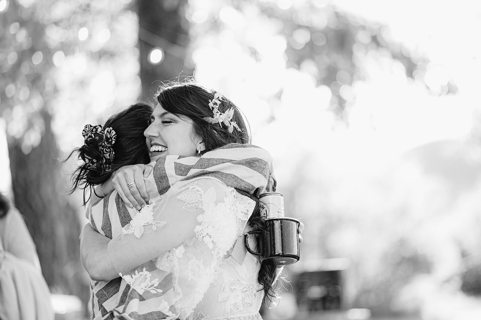 Bride smiling while hugging a friend at the reception - Trout Lake Wedding, WA