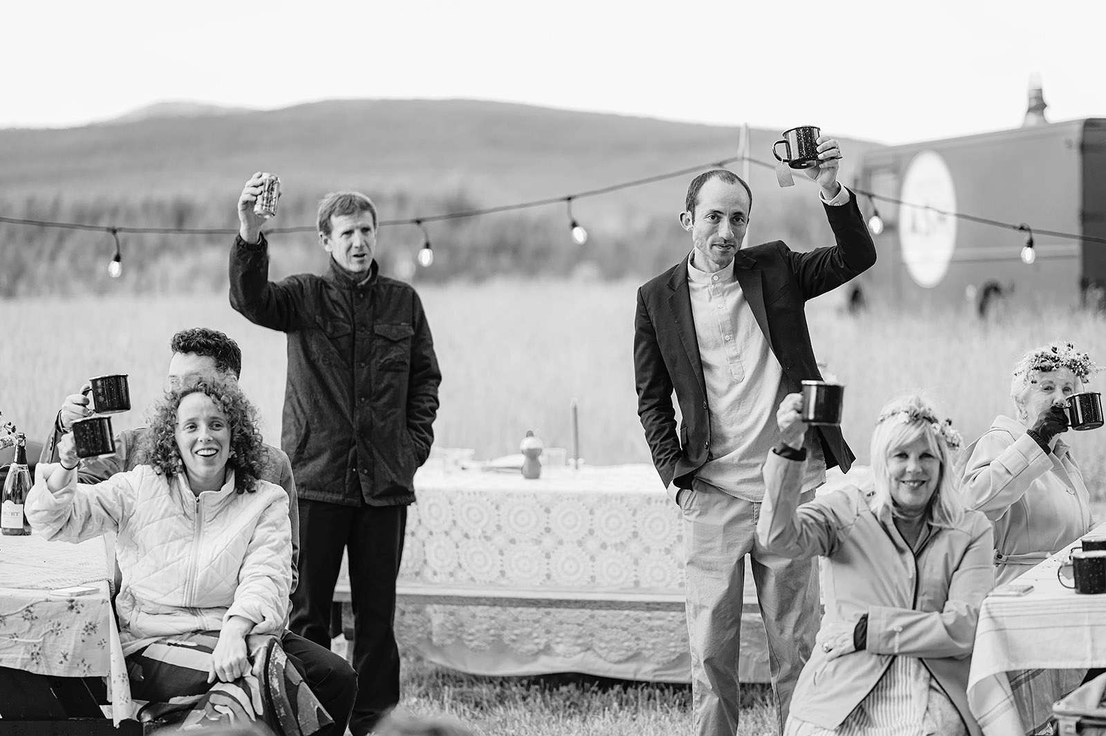 Guests raising their cups in a toast to the bride and groom at the reception at Hollenbeck Park - Trout Lake Wedding, WA
