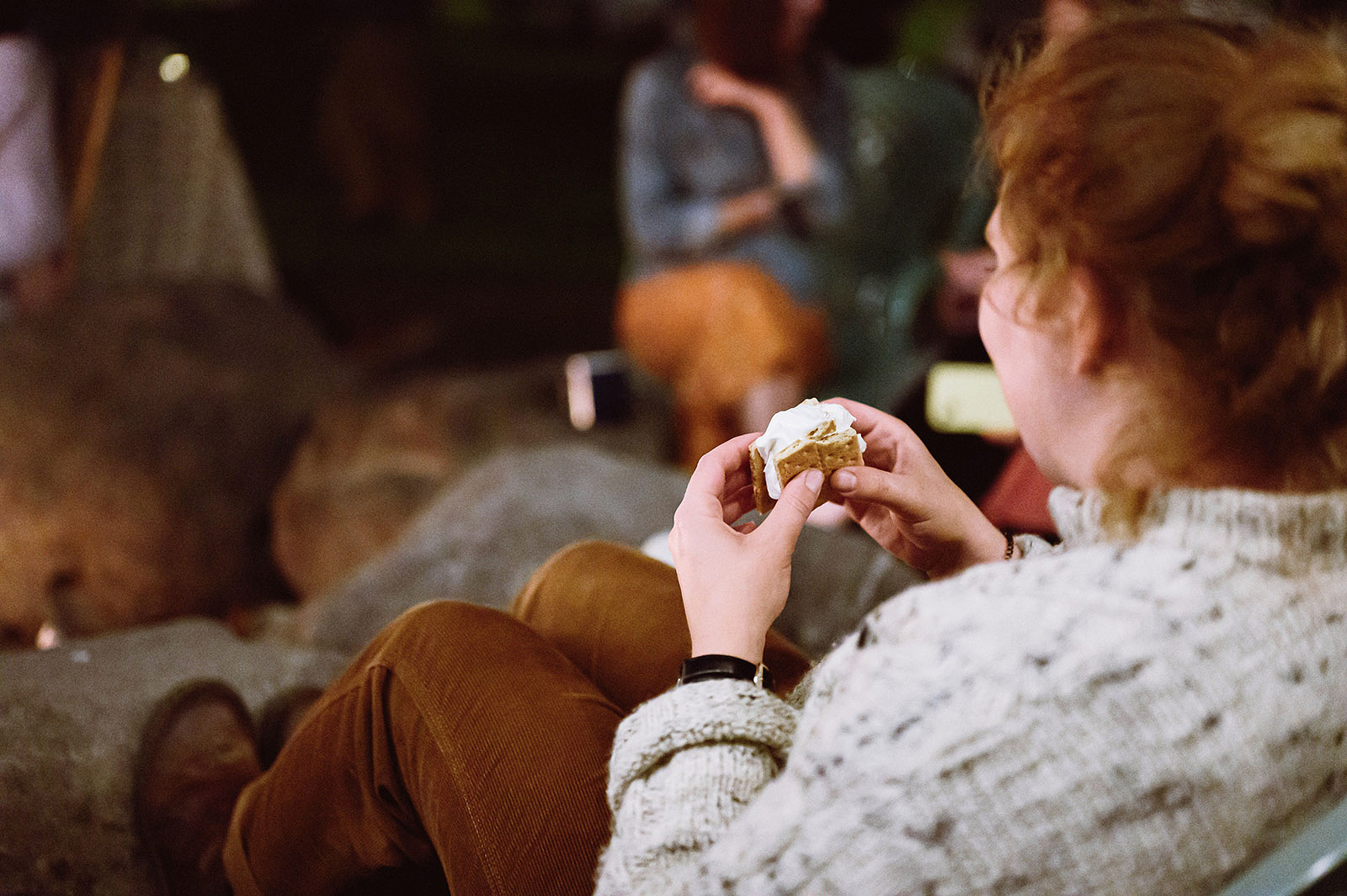 Guest enjoying a s'more next to the fire pit at Hollenbeck Park - Trout Lake Wedding, WA