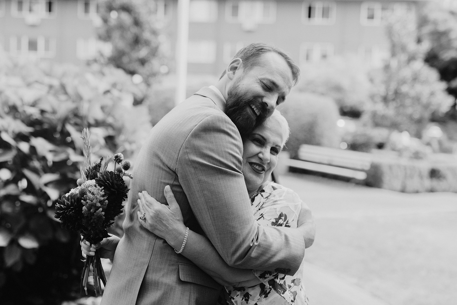 Black and white photo of groom hugging the bride's mom - Oaks Pioneer Church Wedding