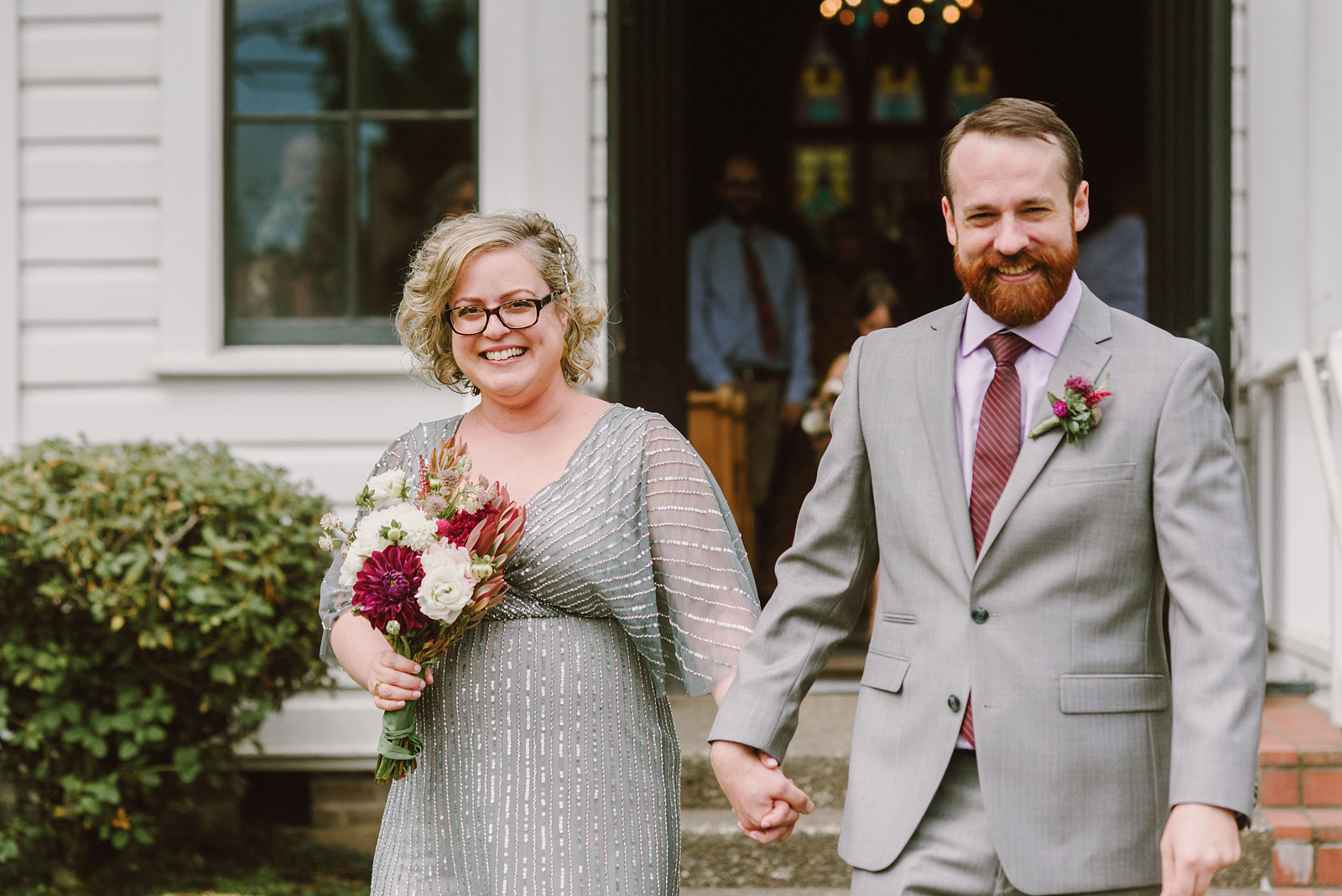 Happy newlyweds holding hands outside of their Oaks Pioneer Church wedding