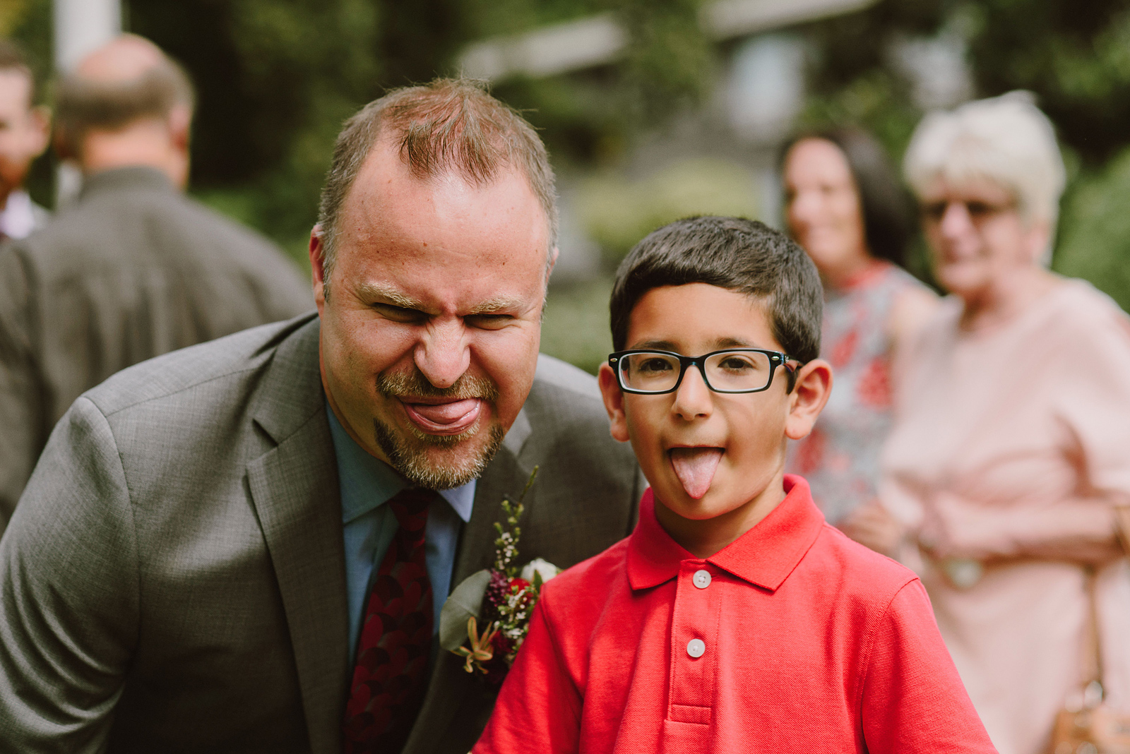 Wedding guest and young child sticking their tongues out at the camera - Oaks Pioneer Church Wedding