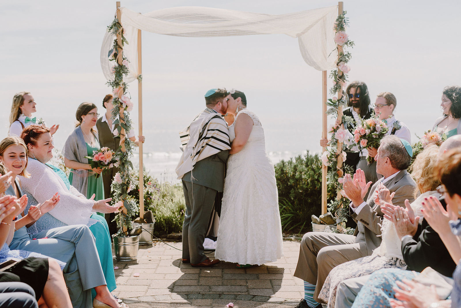 Bride and Groom kissing at the end of a Jewish ceremony - Oceanside Community Club Wedding in Oregon” title=