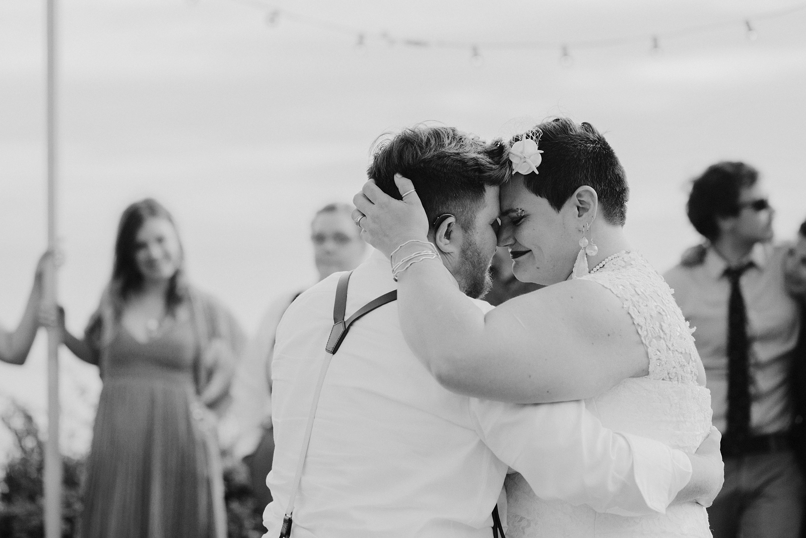 Black and white portrait of bride and groom sharing a tender moment on the dance floor - Oceanside Community Club Wedding on the Oregon Coast” title=