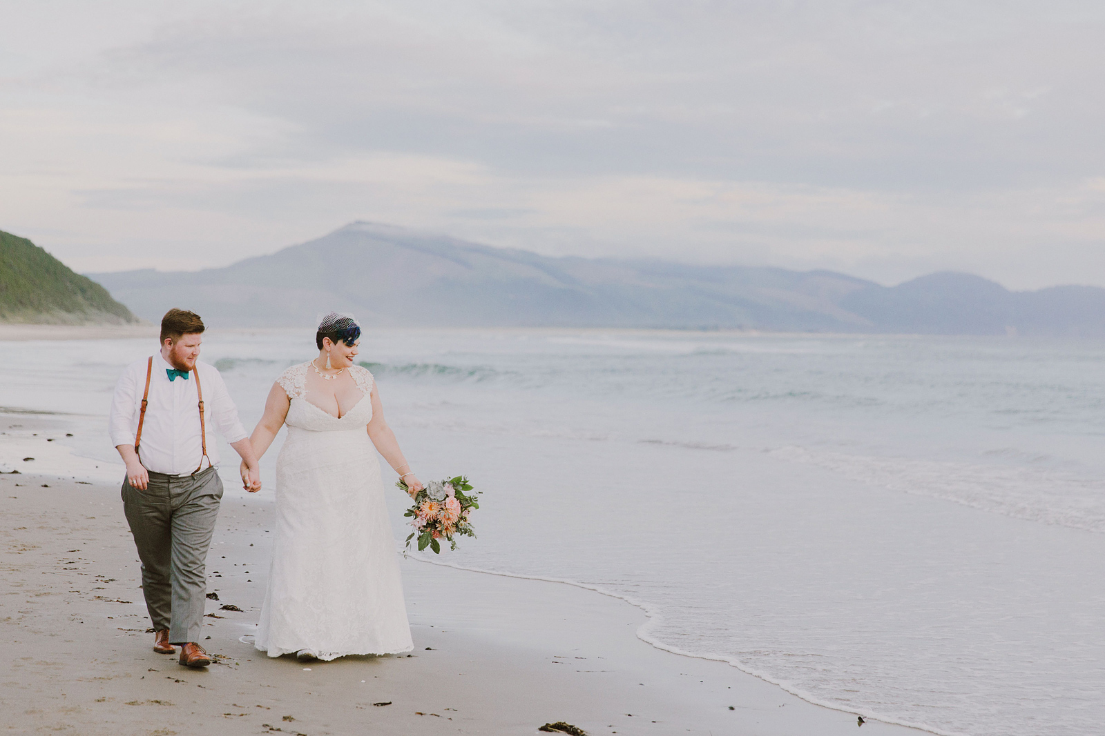 Bride and groom walking along the beach during the golden hour - Oceanside Community Club Wedding” title=